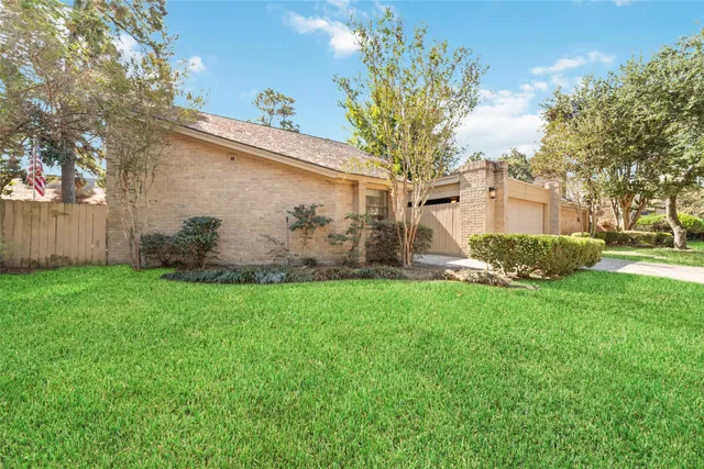 a view of a house with backyard and a tree