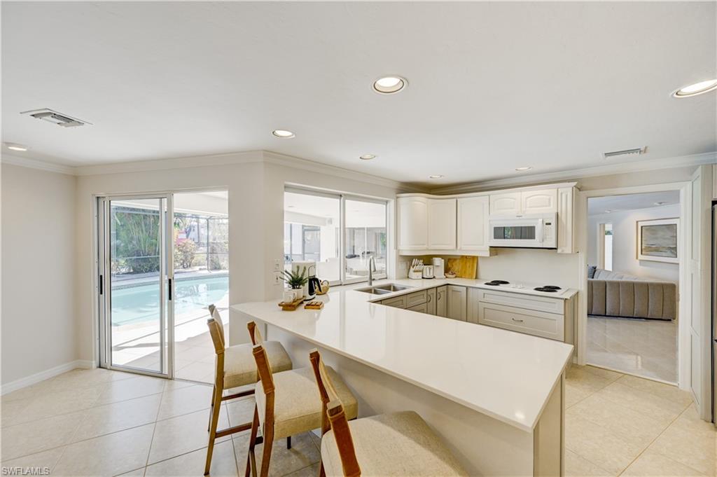 660 14th Avenue South Naples, FL 34102 - Photo 13 of 50 a large kitchen with a table and chairs in it