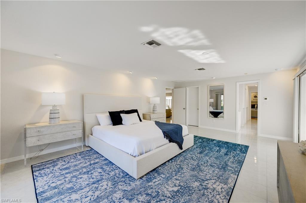 660 14th Avenue South Naples, FL 34102 - Photo 25 of 50 a spacious bedroom with a bed a rug and wooden floor
