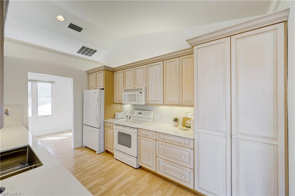 660 14th Avenue South Naples, FL 34102 - Photo 43 of 50 a kitchen with white cabinets and white appliances