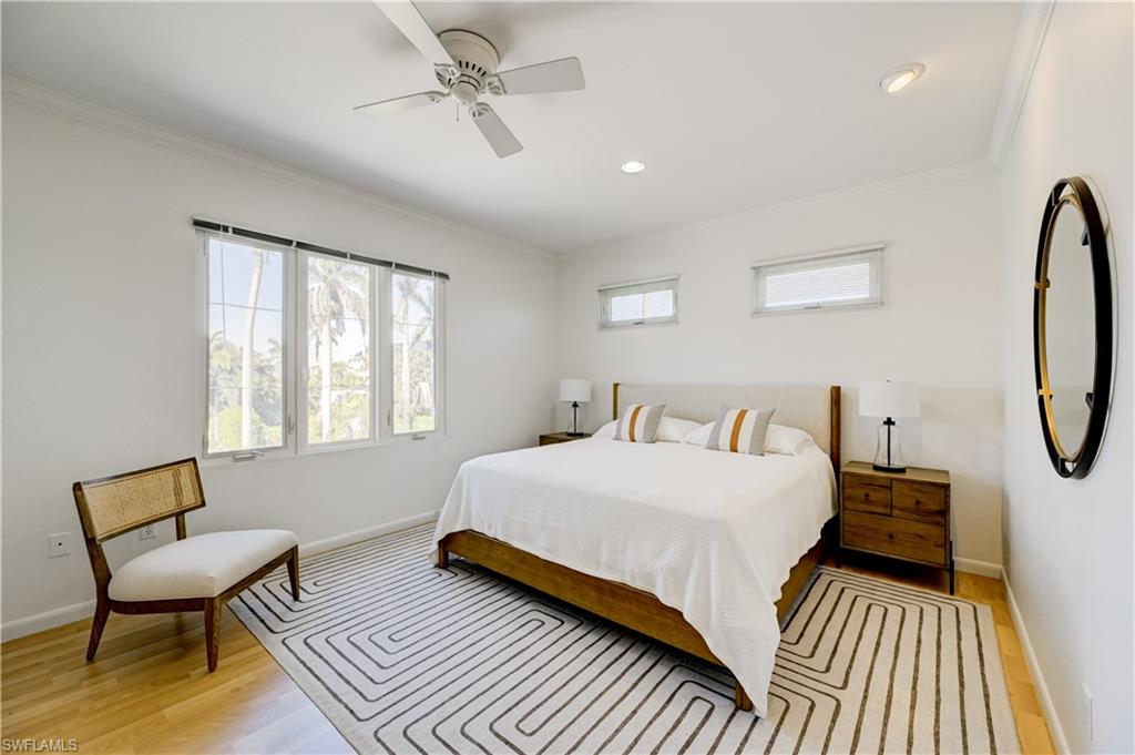 660 14th Avenue South Naples, FL 34102 - Photo 46 of 50 a bedroom with a bed a chandelier and a window