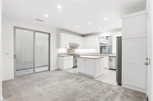 a kitchen with white cabinets and white appliances