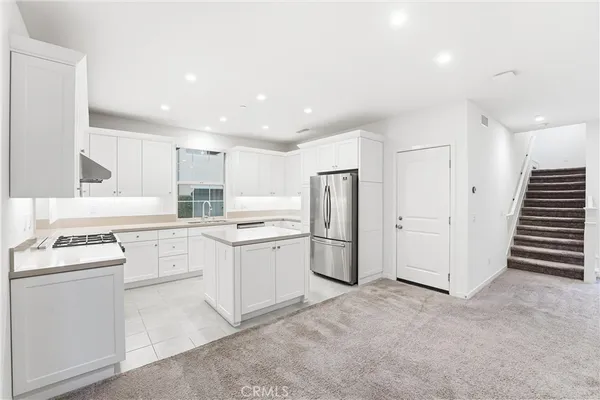 a kitchen with white cabinets and white appliances