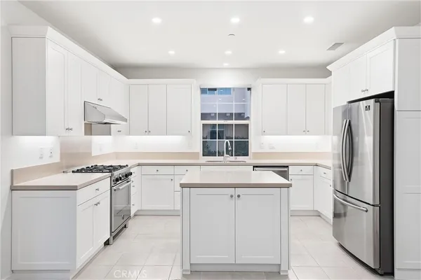 a kitchen with a stove a refrigerator and a sink