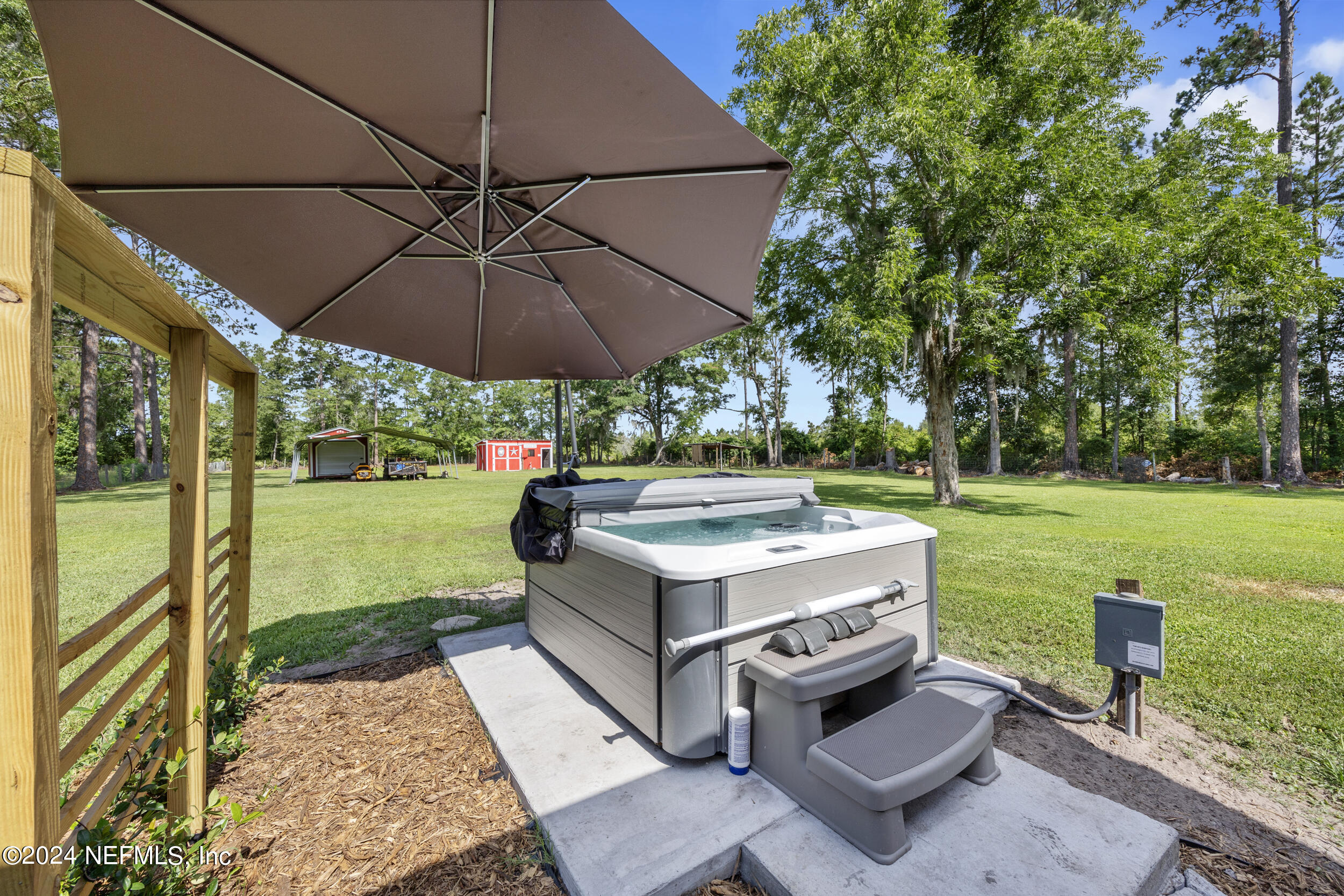 8912 McClelland Road Jacksonville, FL 32234 - Photo 13 of 49 a view of a patio with a table chairs under an umbrella