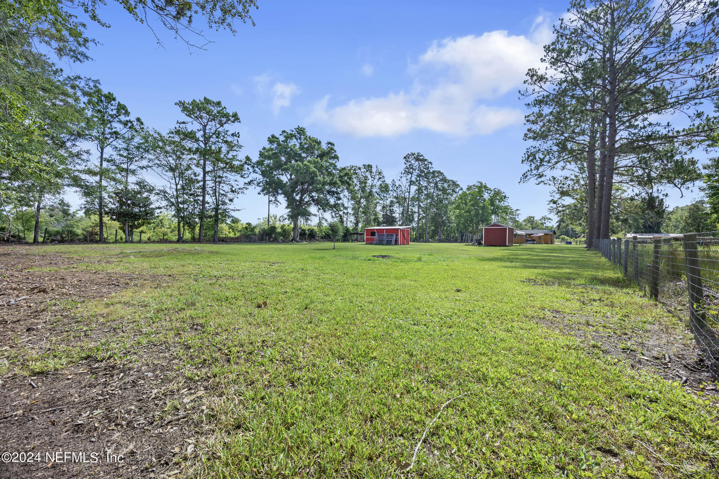 8912 McClelland Road Jacksonville, FL 32234 - Photo 14 of 49 a view of a grassy field with trees around
