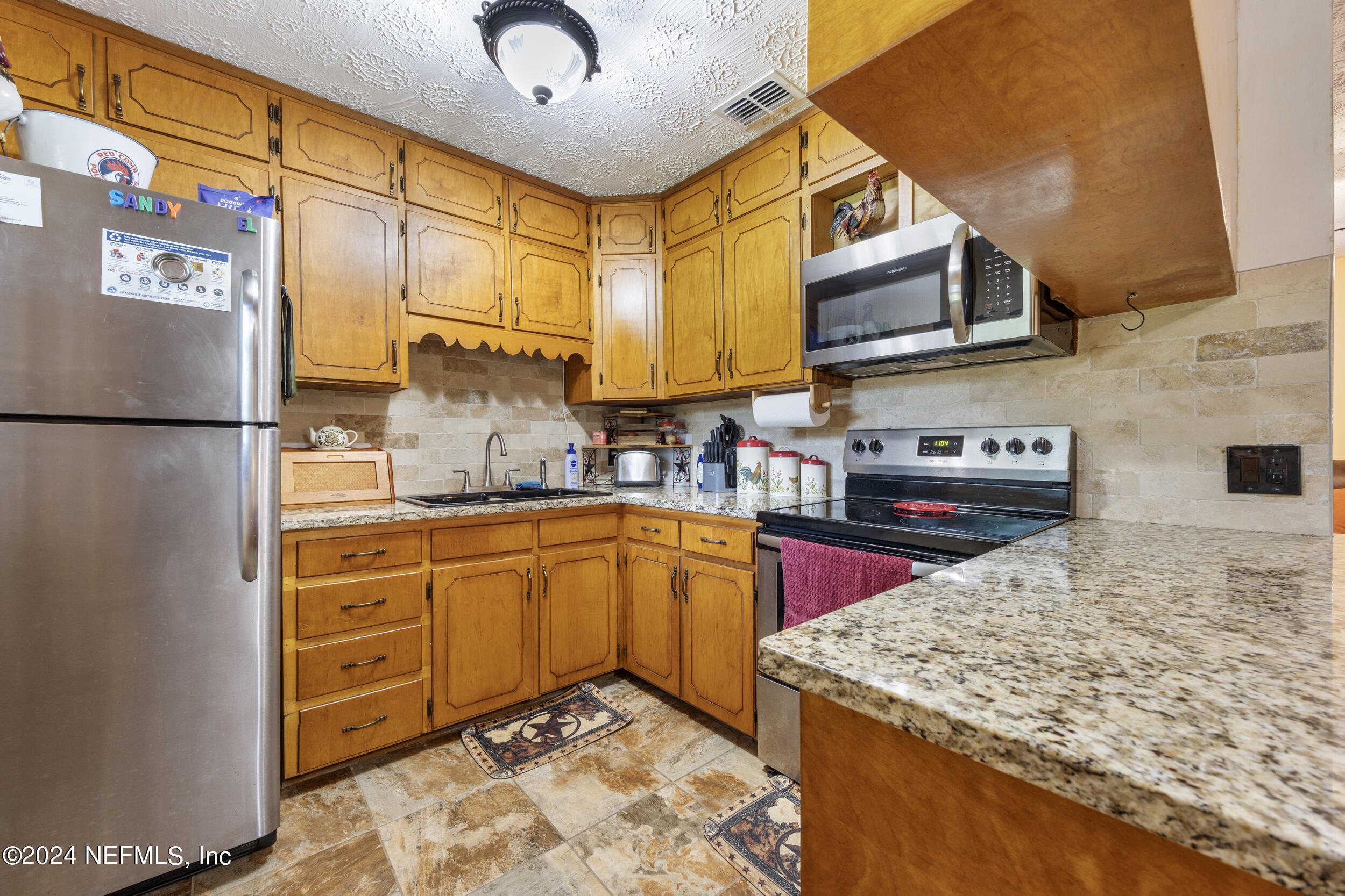 8912 McClelland Road Jacksonville, FL 32234 - Photo 25 of 49 a kitchen with stainless steel appliances granite countertop a sink stove and refrigerator