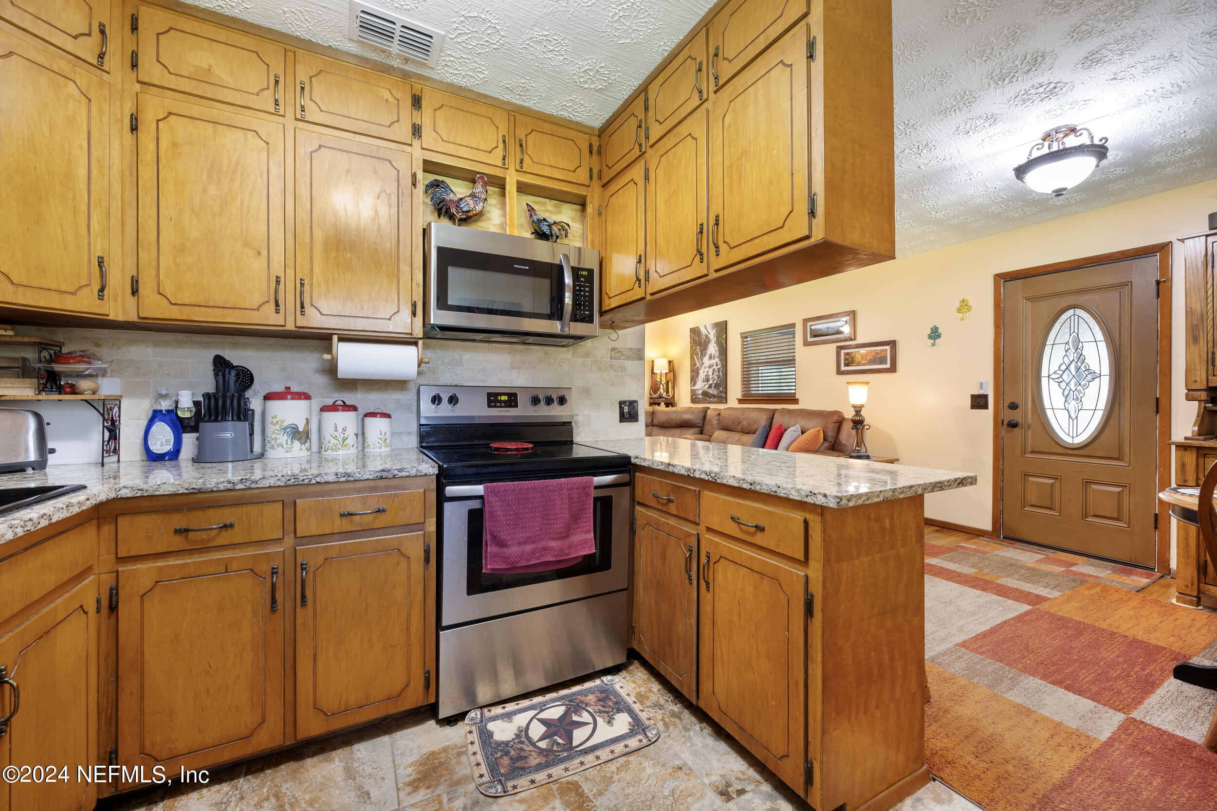 8912 McClelland Road Jacksonville, FL 32234 - Photo 26 of 49 a kitchen with stainless steel appliances granite countertop a stove a sink dishwasher and cabinets with wooden floor