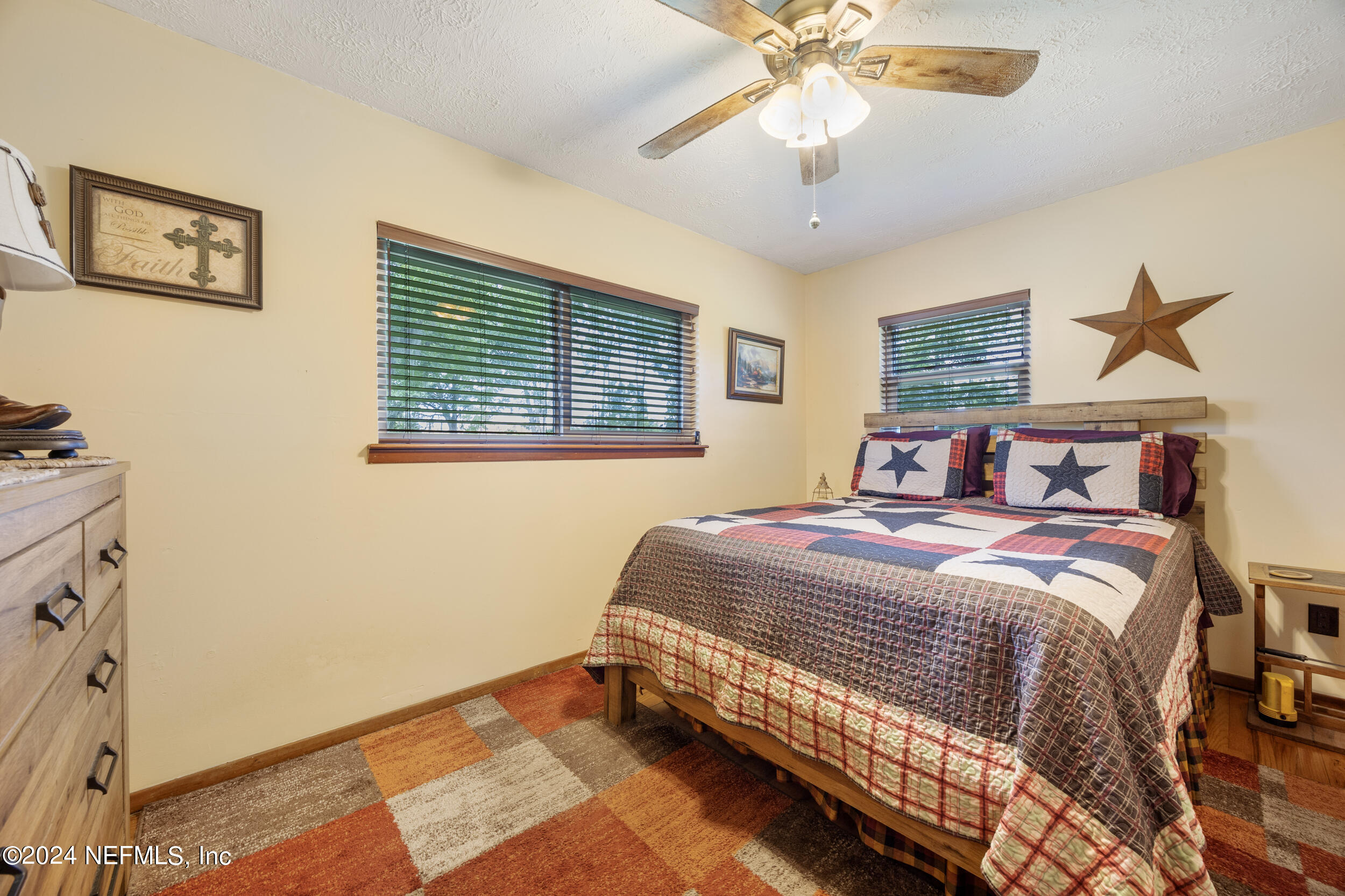 8912 McClelland Road Jacksonville, FL 32234 - Photo 30 of 49 a bedroom with a bed and a chandelier