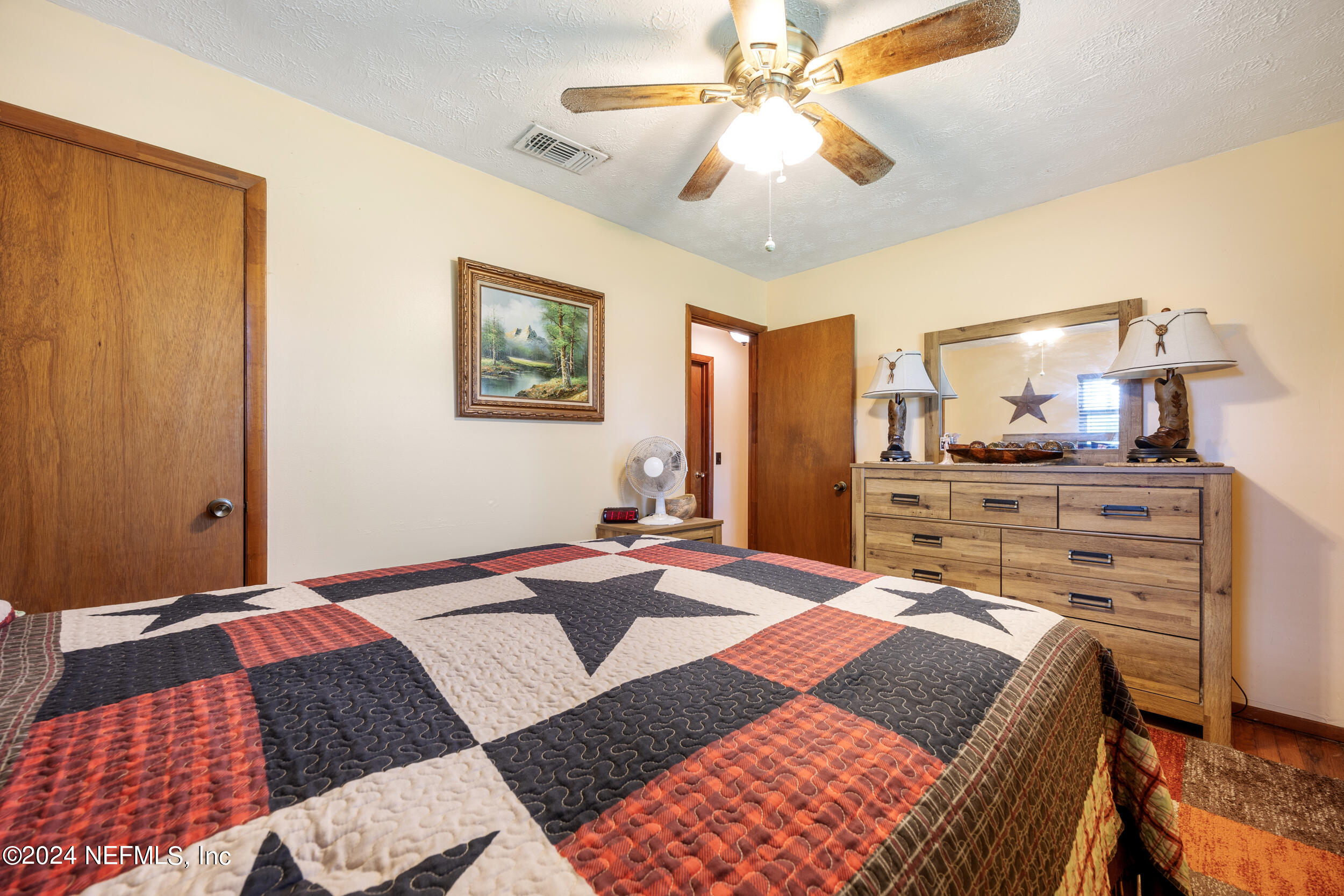 8912 McClelland Road Jacksonville, FL 32234 - Photo 33 of 49 a bedroom with a bed and wooden floor