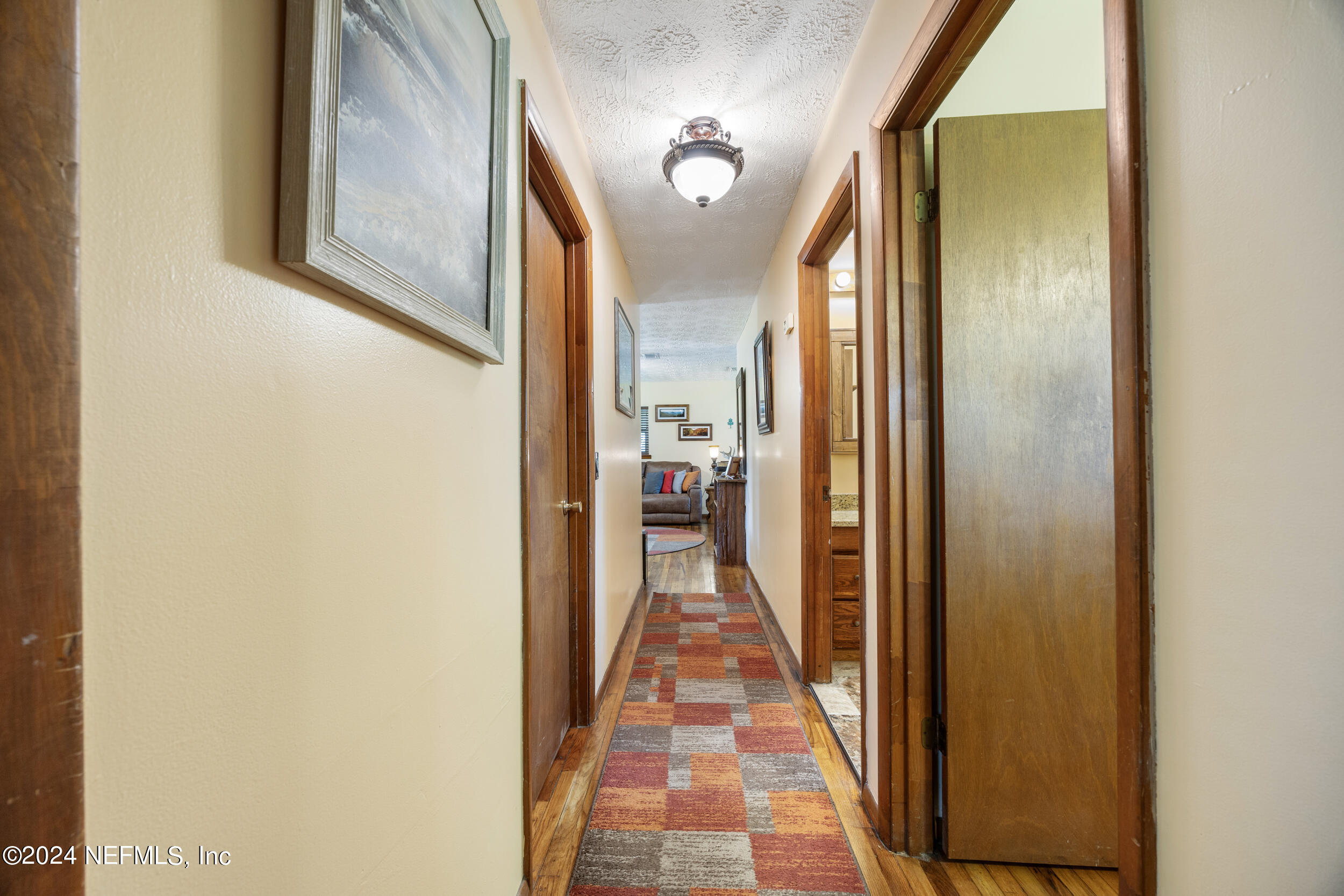 8912 McClelland Road Jacksonville, FL 32234 - Photo 36 of 49 a view of a hallway with wooden floor and a bathroom