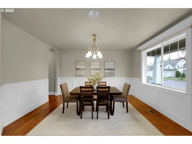 a view of a dining room with furniture a chandelier and wooden floor