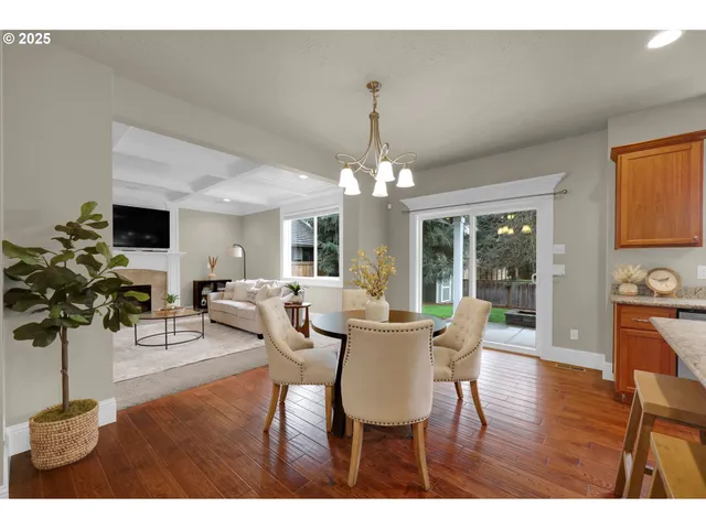 a dining room with furniture potted plants and wooden floor
