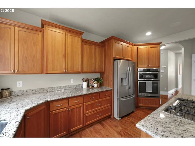 a kitchen with stainless steel appliances granite countertop a refrigerator a sink and dishwasher