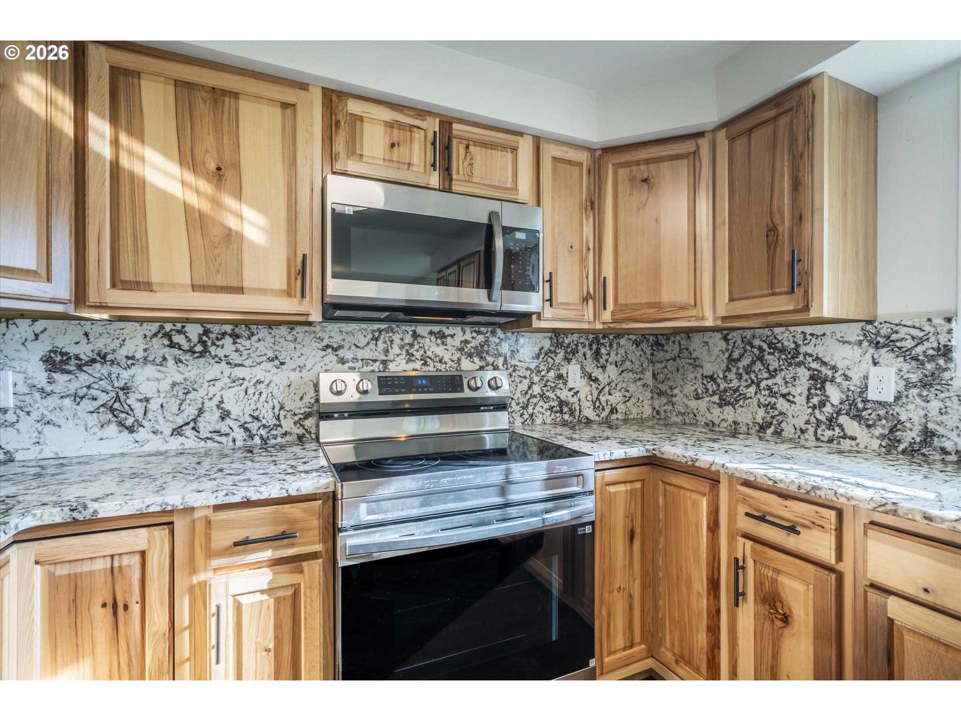 950 1st Street Northeast Bandon, OR 97411 - Photo 11 of 45 a kitchen with granite countertop a sink stove and cabinets