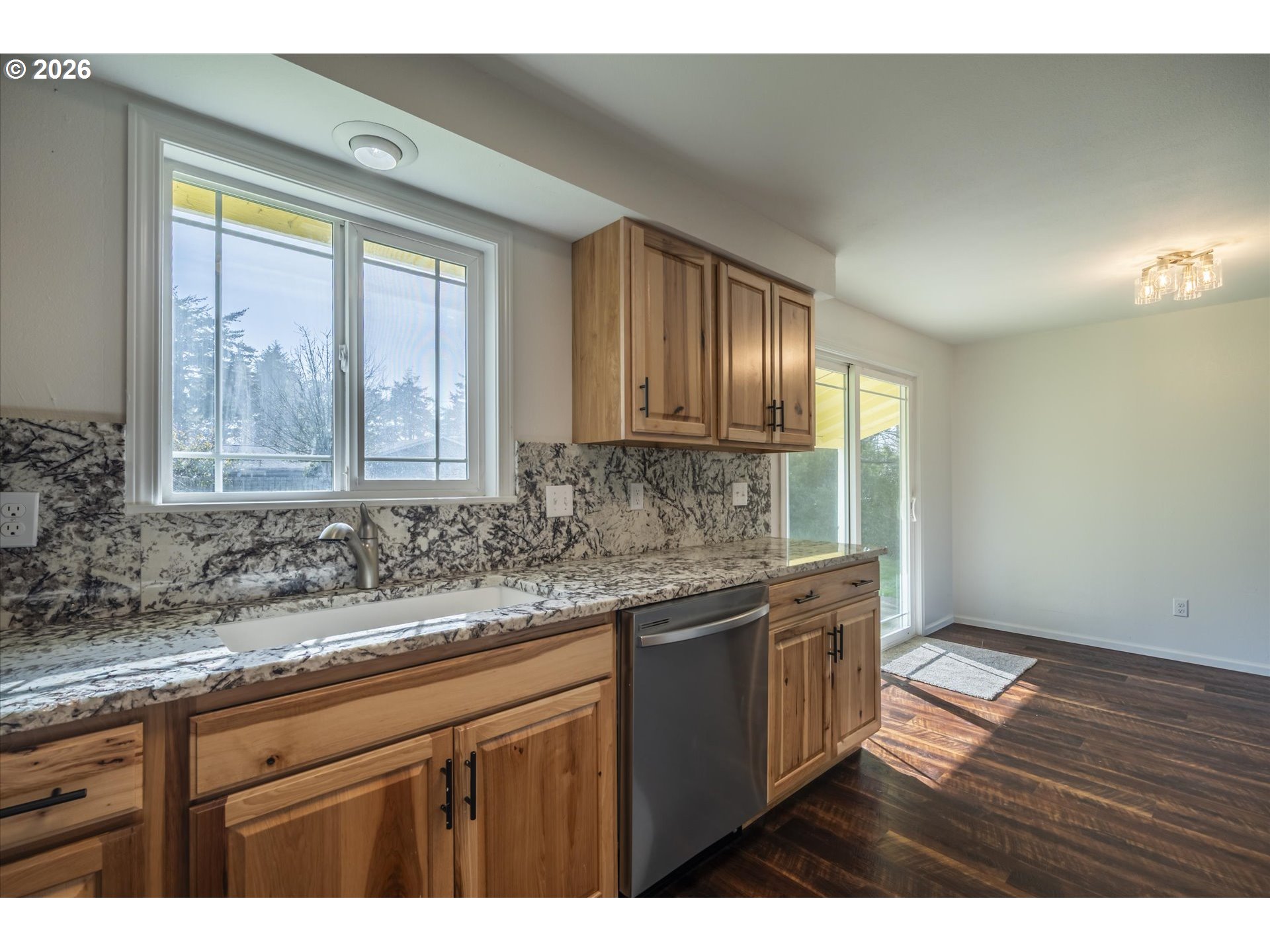 950 1st Street Northeast Bandon, OR 97411 - Photo 13 of 45 a kitchen with granite countertop wooden cabinets a sink and a window