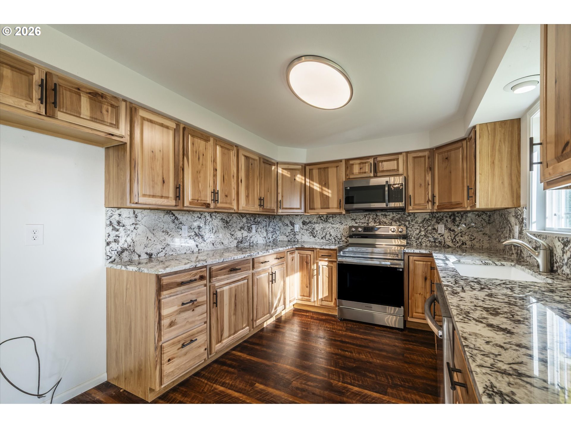 950 1st Street Northeast Bandon, OR 97411 - Photo 14 of 45 a kitchen with stainless steel appliances granite countertop a stove top oven a sink dishwasher a microwave oven with cabinets and wooden floor