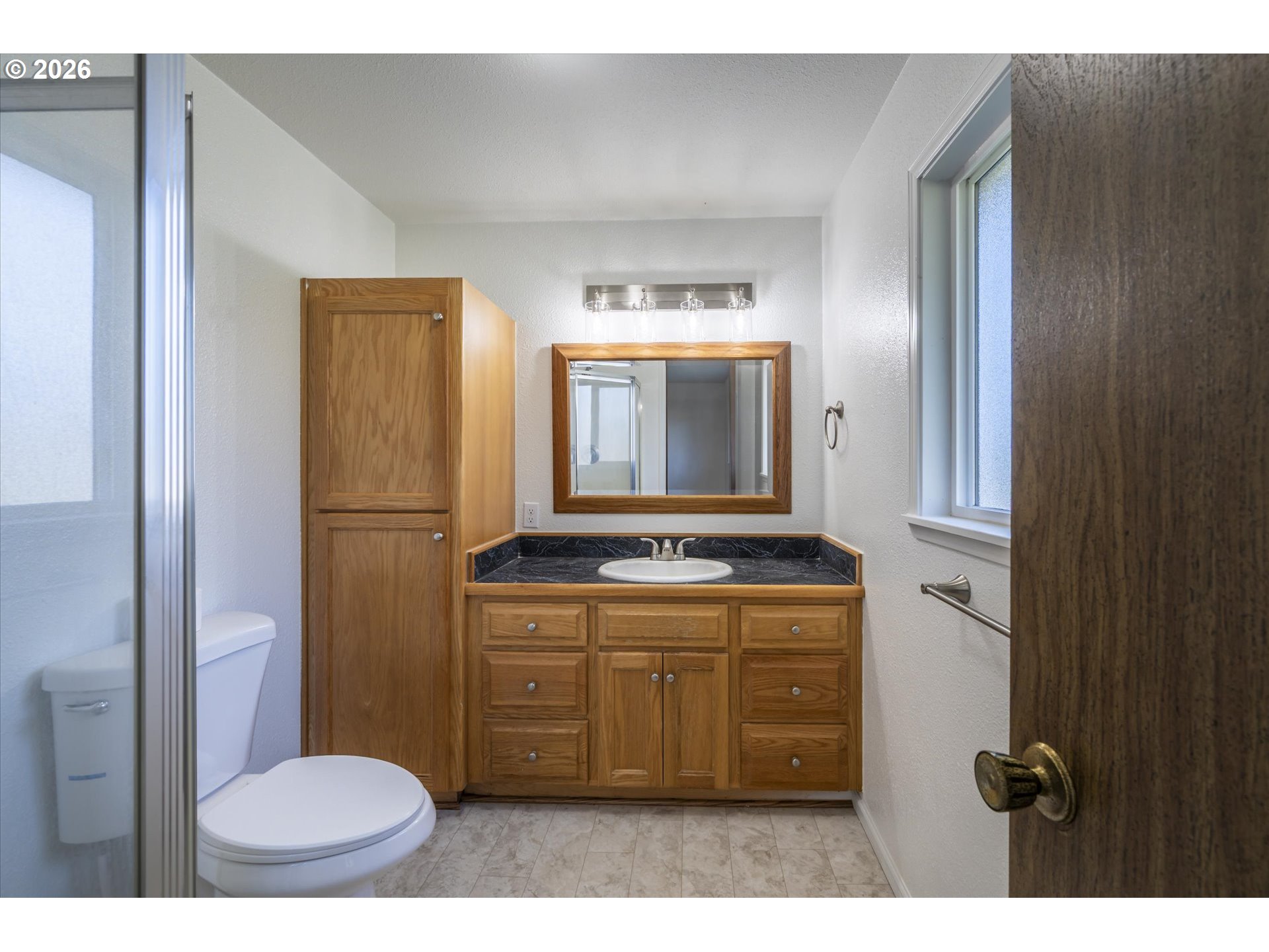 950 1st Street Northeast Bandon, OR 97411 - Photo 23 of 45 a bathroom with a granite countertop sink a toilet mirror and vanity