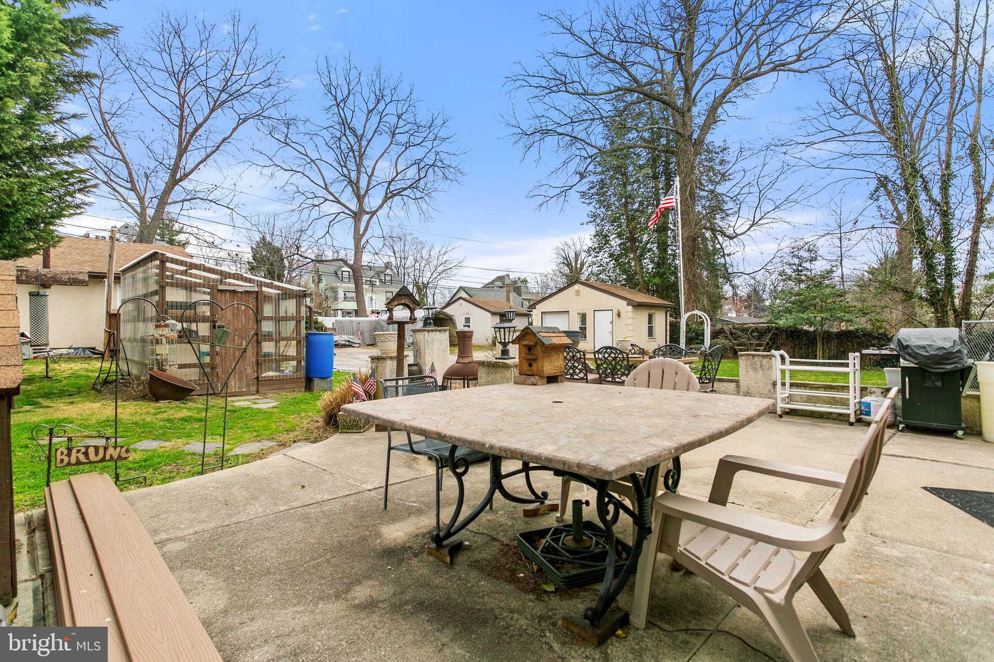 341 Owen Avenue Lansdowne, PA 19050 - Photo 39 of 58 a view of a backyard with table and chairs and a barbeque with potted plants and large trees