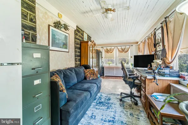 a living room with furniture a large window and wooden floor