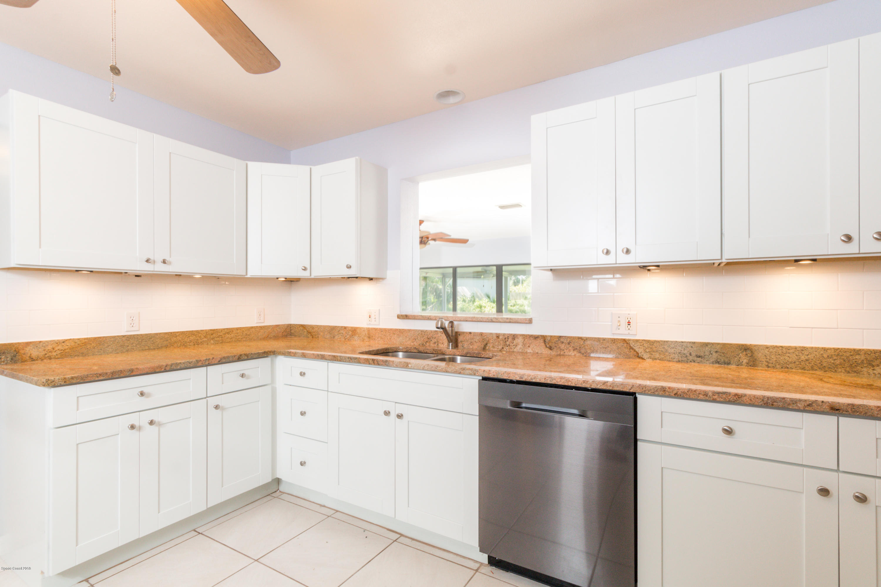 1208 Cimarron Circle Northeast Palm Bay, FL 32905 - Photo 13 of 41 a kitchen with white cabinets appliances and a window
