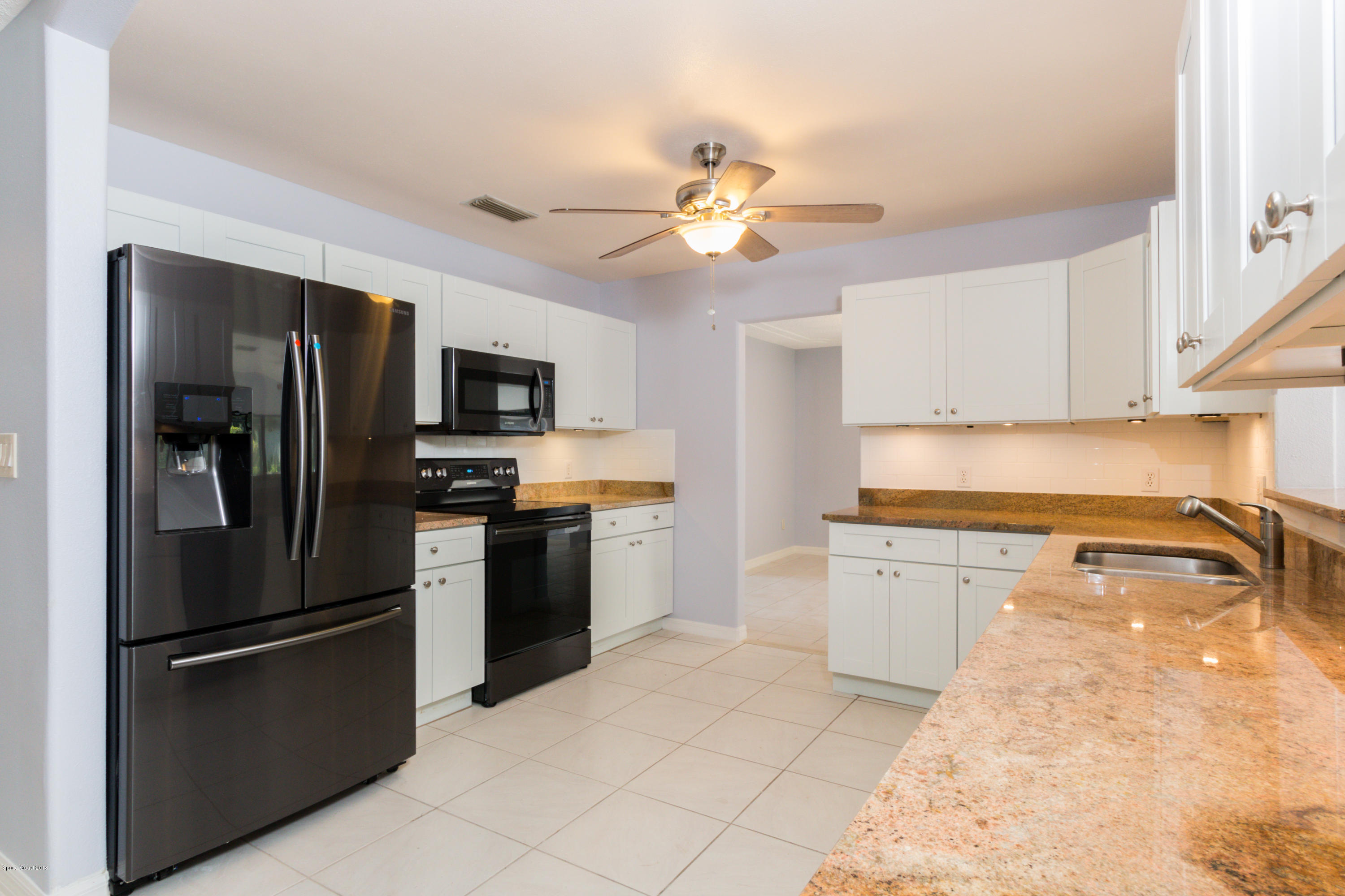 1208 Cimarron Circle Northeast Palm Bay, FL 32905 - Photo 15 of 41 a kitchen with stainless steel appliances granite countertop a refrigerator a stove and a sink