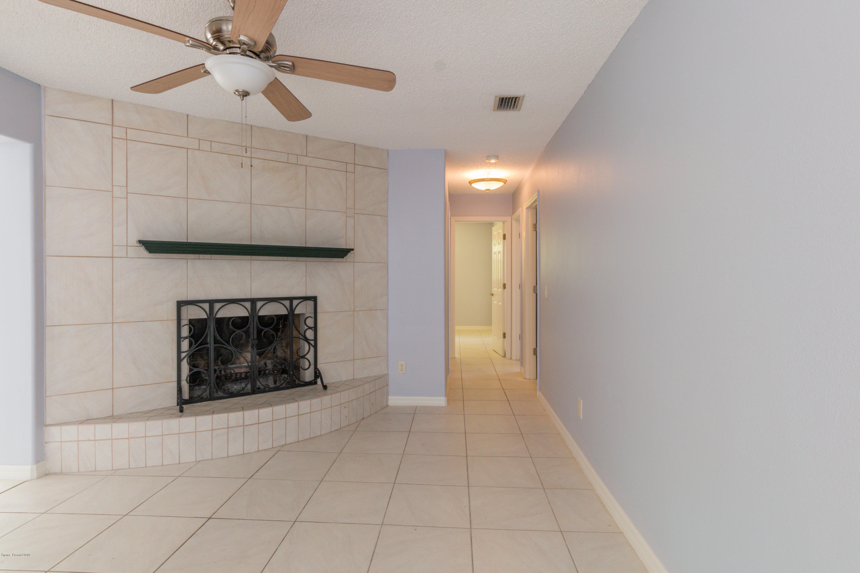 1208 Cimarron Circle Northeast Palm Bay, FL 32905 - Photo 19 of 41 a view of a livingroom with a fireplace and fan
