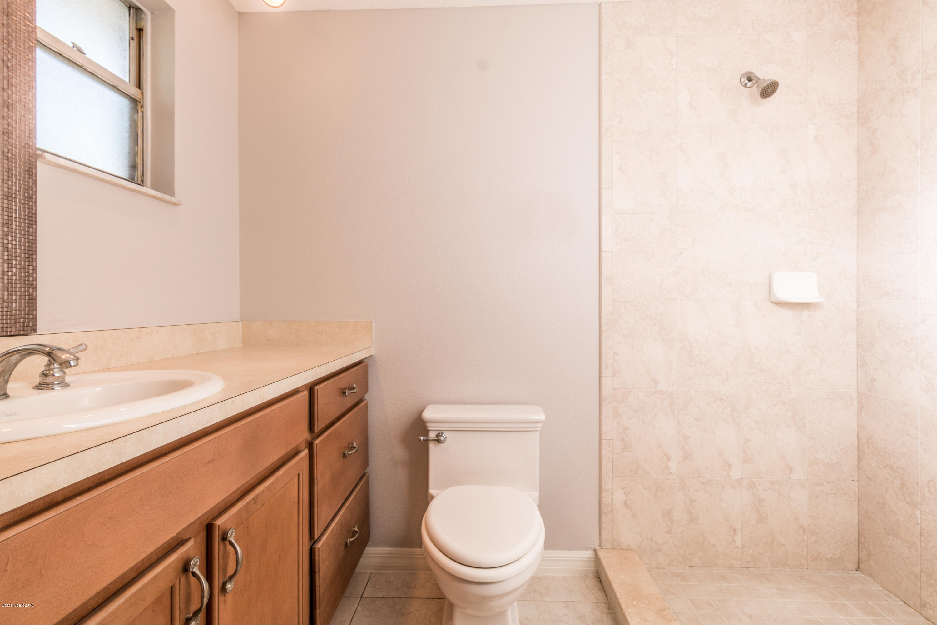 1208 Cimarron Circle Northeast Palm Bay, FL 32905 - Photo 25 of 41 a bathroom with a granite countertop toilet sink and mirror