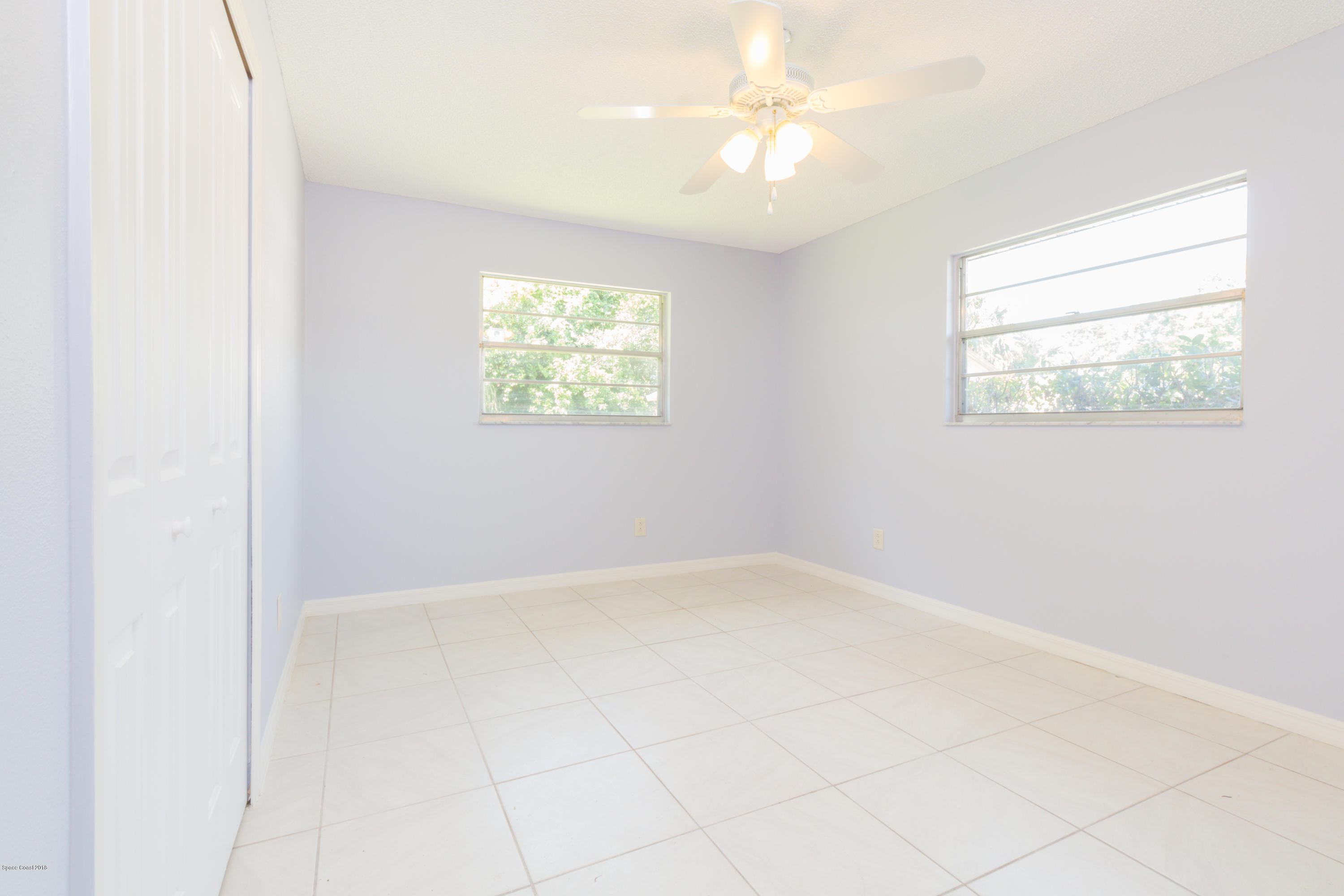 1208 Cimarron Circle Northeast Palm Bay, FL 32905 - Photo 27 of 41 an empty room with windows and fan