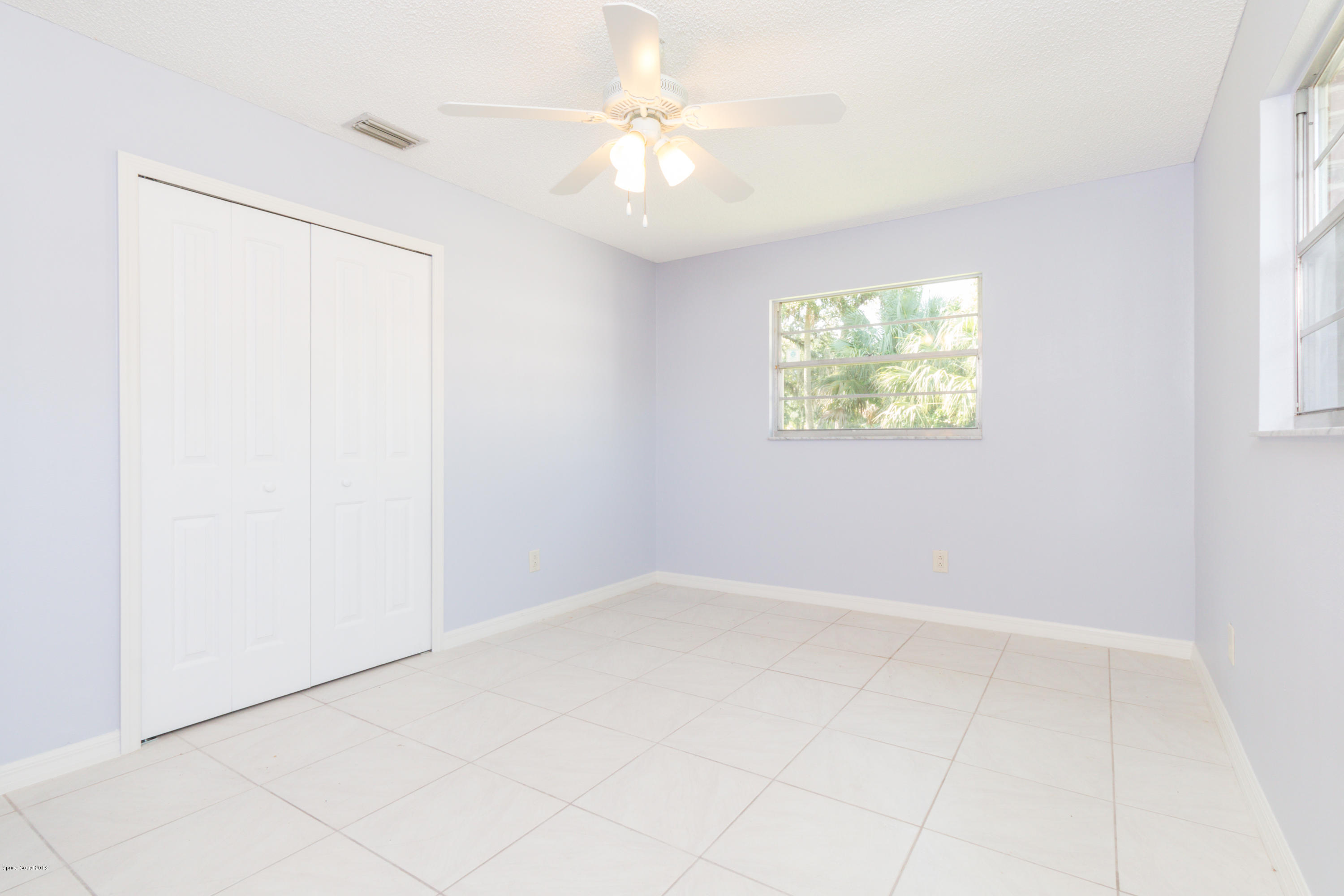 1208 Cimarron Circle Northeast Palm Bay, FL 32905 - Photo 28 of 41 an empty room with windows and fan