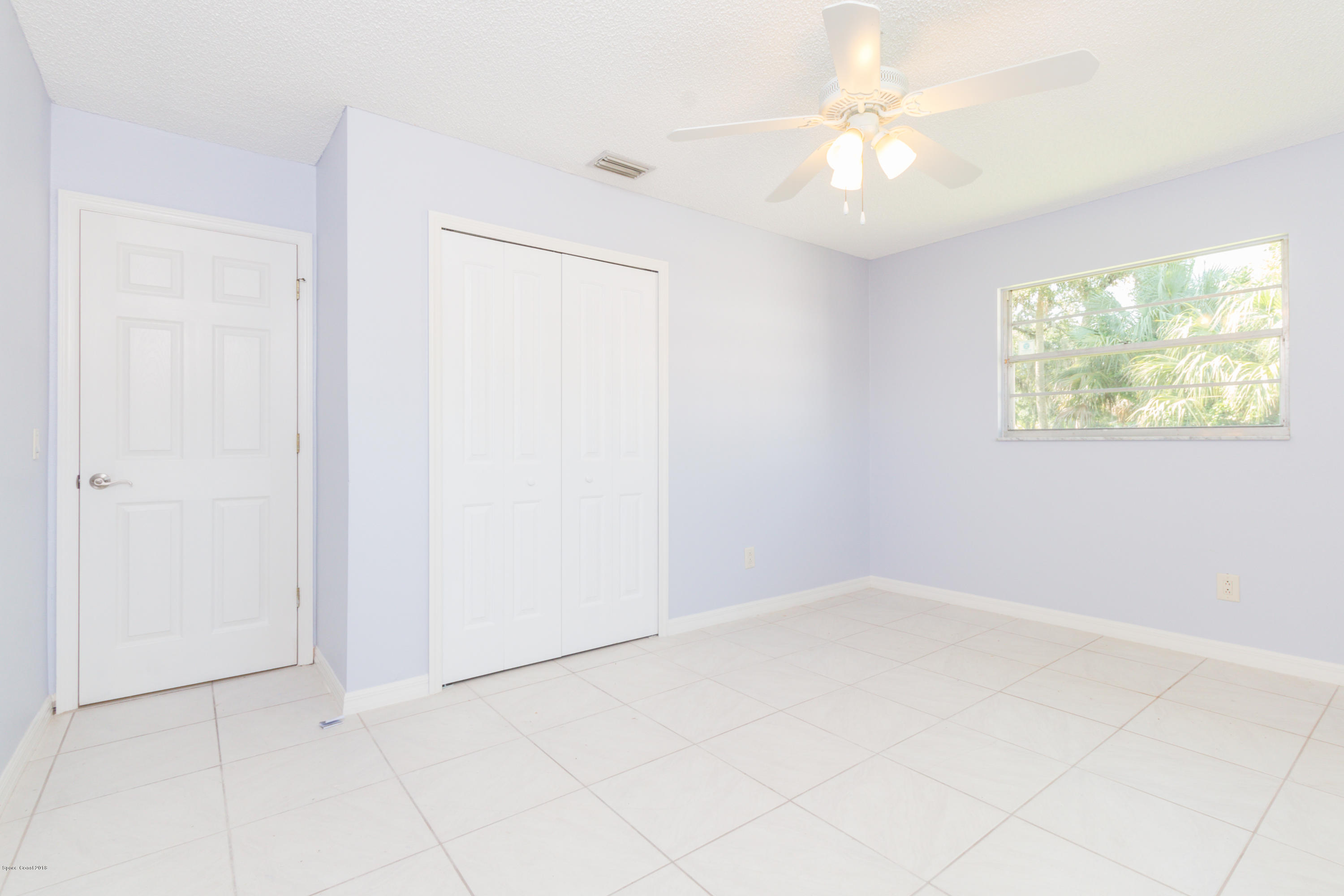 1208 Cimarron Circle Northeast Palm Bay, FL 32905 - Photo 29 of 41 an empty room with windows and fan