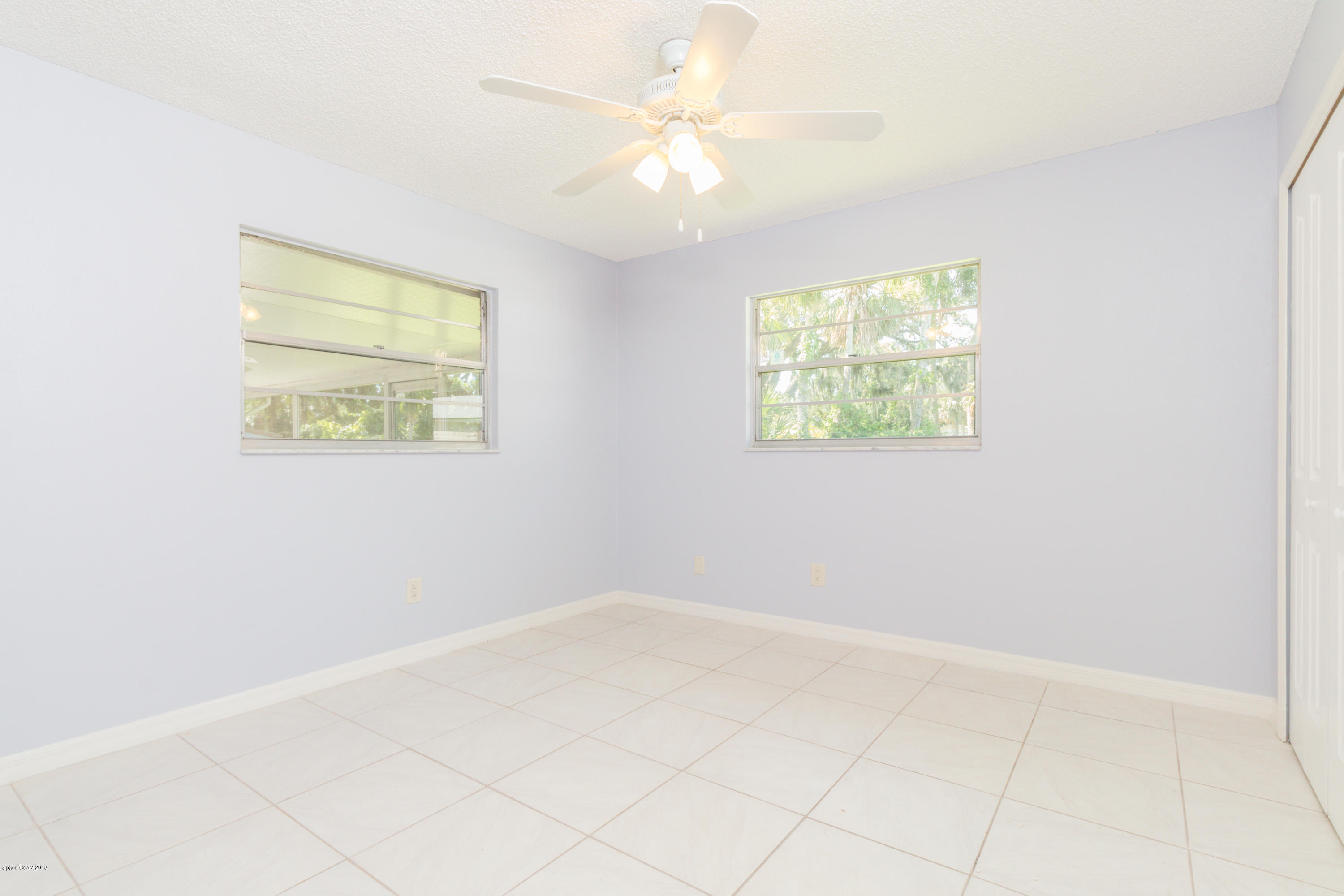 1208 Cimarron Circle Northeast Palm Bay, FL 32905 - Photo 30 of 41 an empty room with windows and fan
