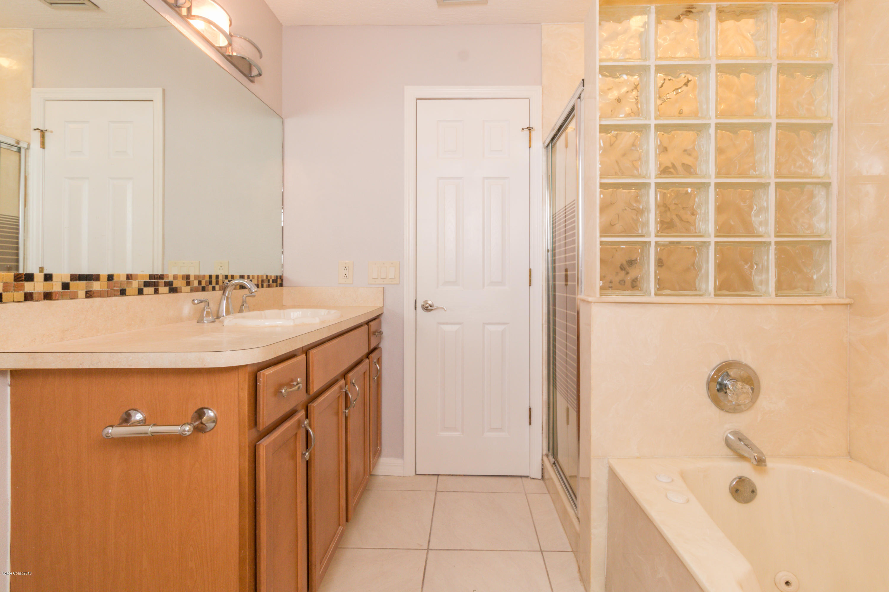 1208 Cimarron Circle Northeast Palm Bay, FL 32905 - Photo 33 of 41 a bathroom with a sink a mirror and a bathtub
