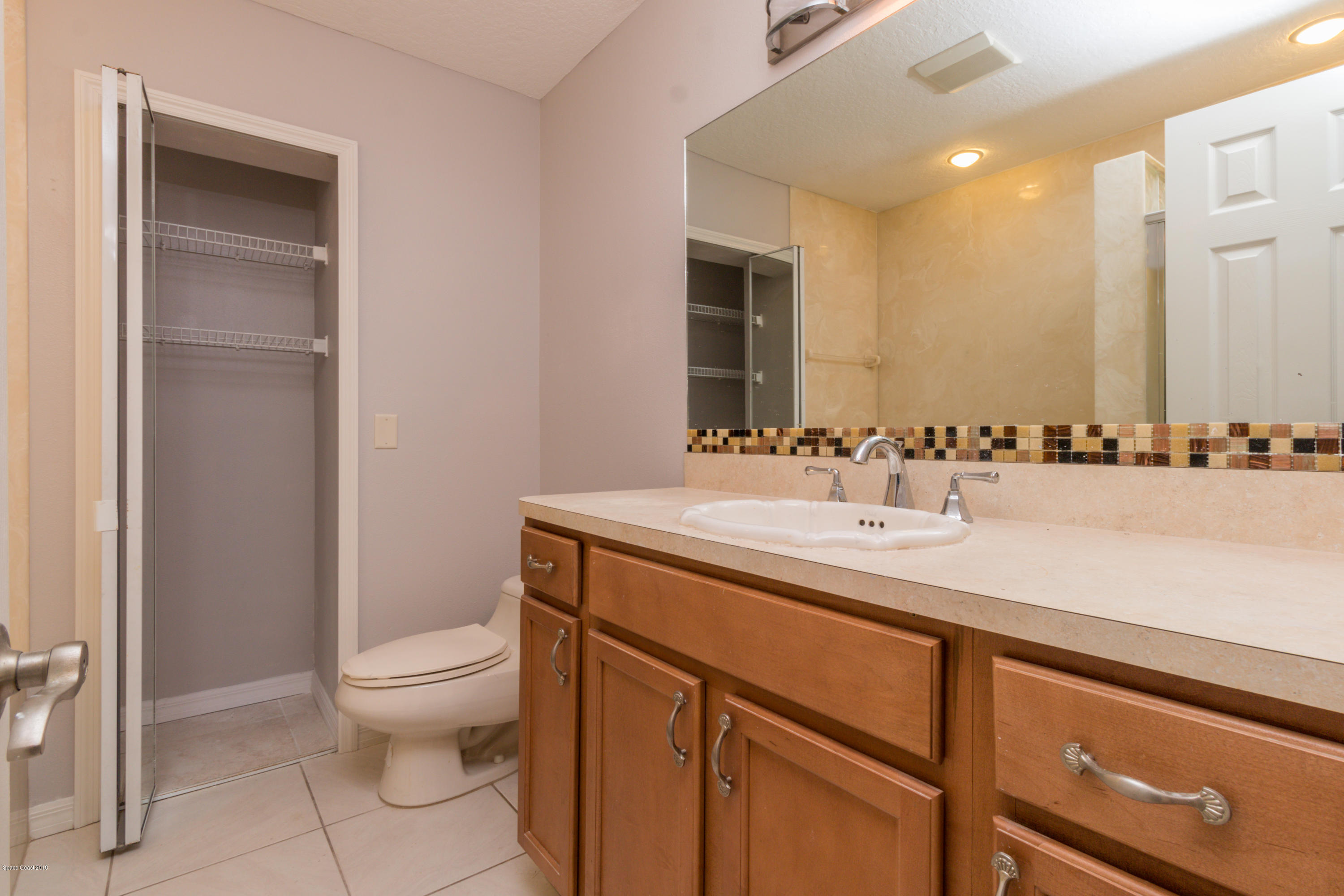 1208 Cimarron Circle Northeast Palm Bay, FL 32905 - Photo 34 of 41 a bathroom with a sink a toilet and a mirror