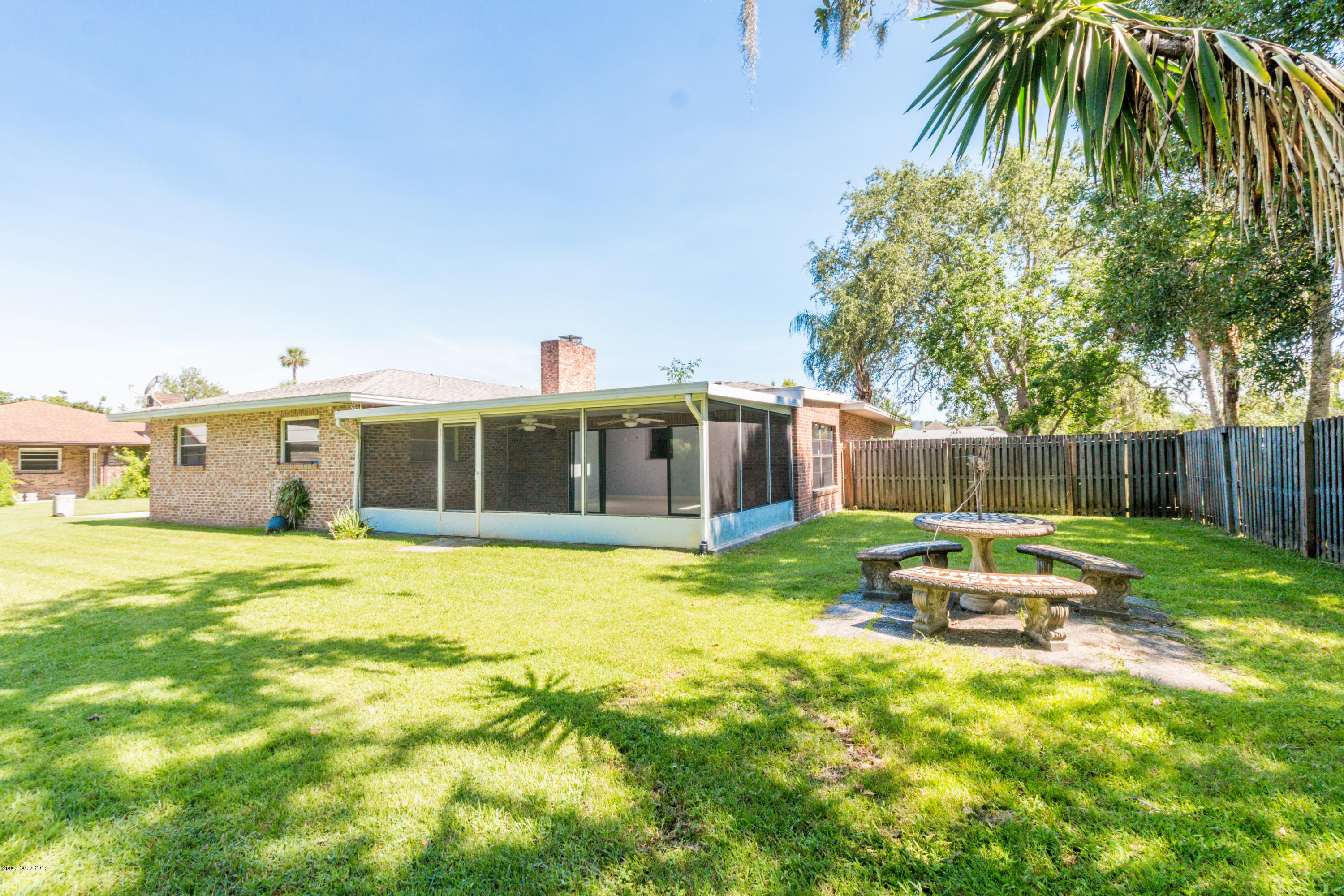 1208 Cimarron Circle Northeast Palm Bay, FL 32905 - Photo 38 of 41 a backyard of a house with table and chairs