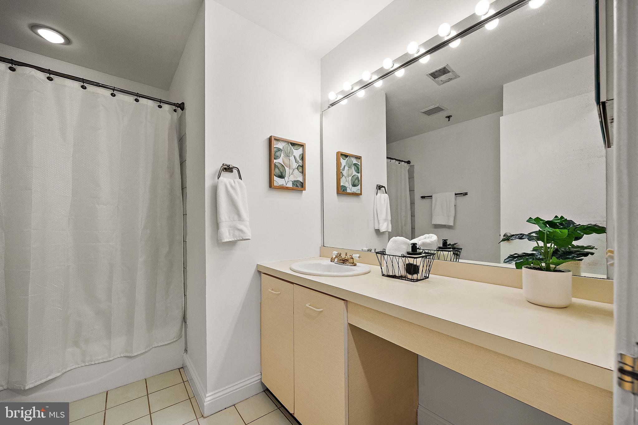 49 Bancroft Mills Road, Unit 2I Wilmington, DE 19806 - Photo 22 of 27 a bathroom with a sink a mirror and a shower