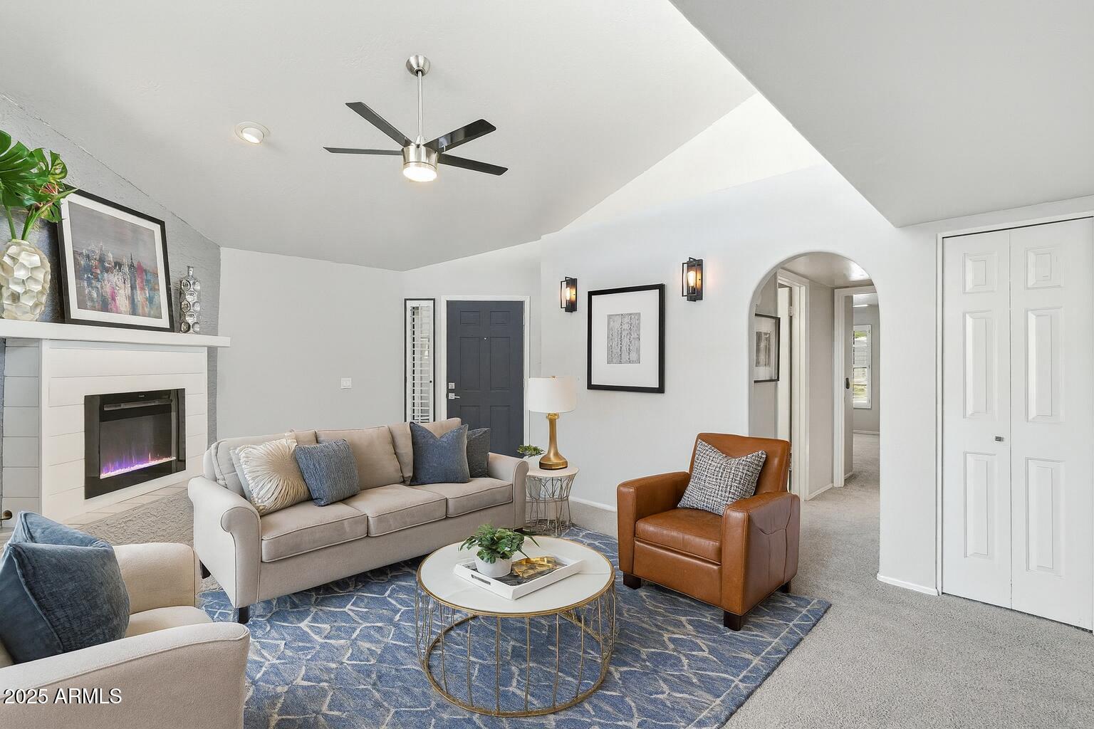 18002 North 12th Street, Unit 26 Phoenix, AZ 85022 - Photo 3 of 25 a living room with furniture a fireplace and a table