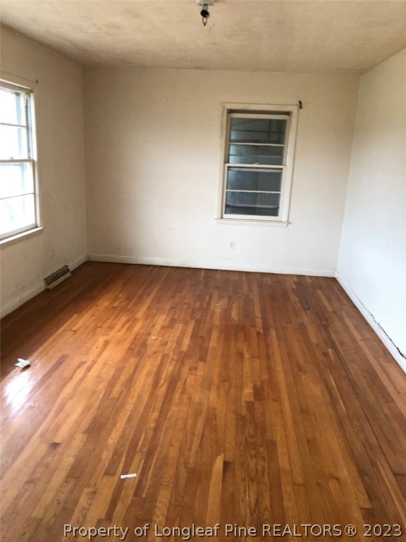 199 Herring Road Orrum, NC 28369 - Photo 9 of 20 an empty room with wooden floor and windows