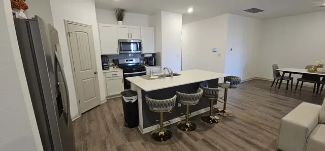 a kitchen with a table chairs refrigerator and microwave