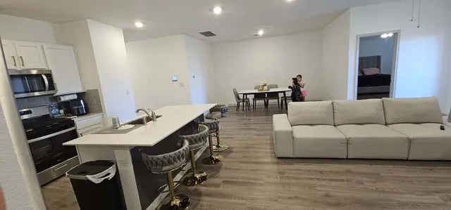a living room with furniture a sink and a refrigerator