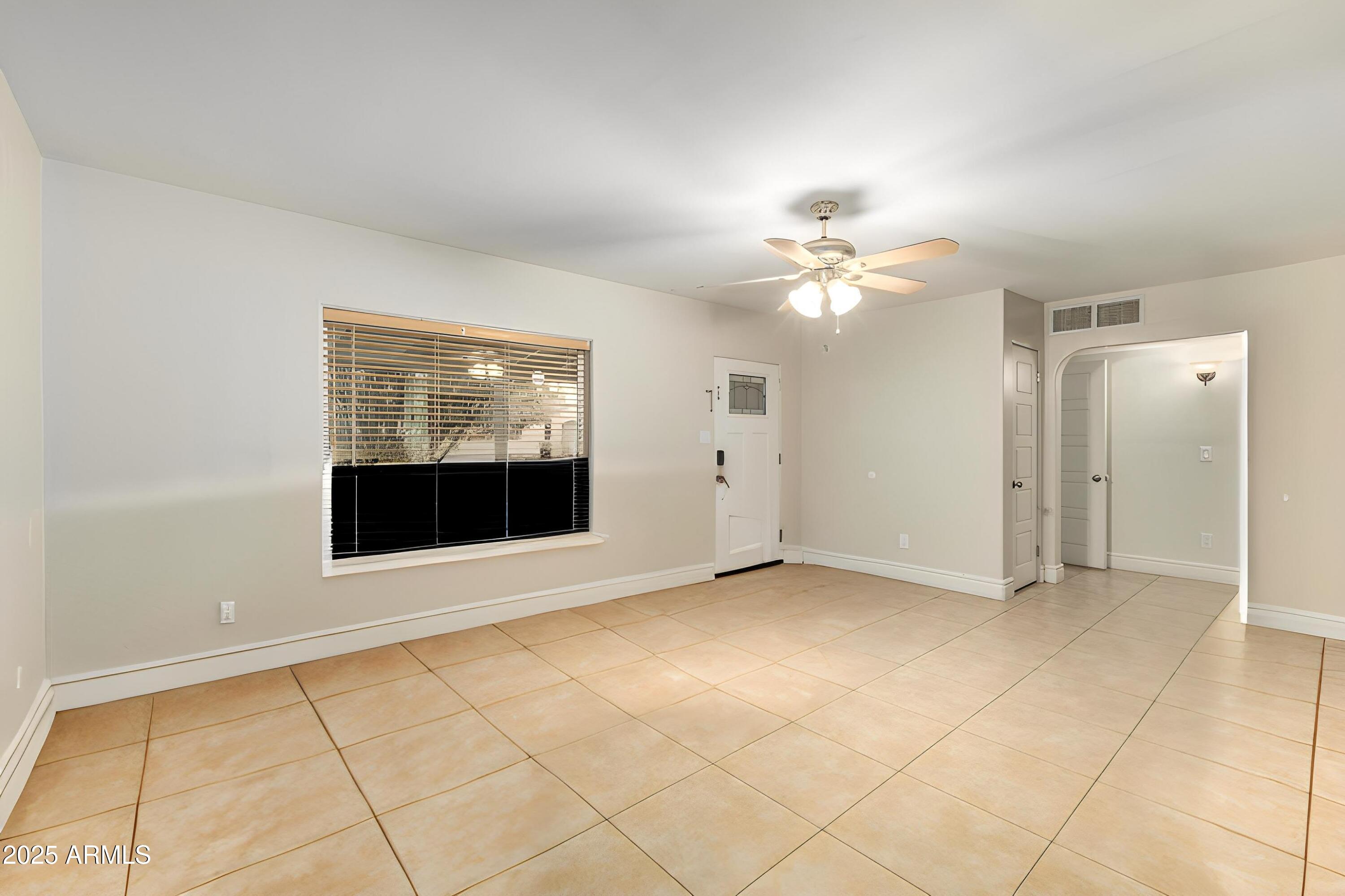 6842 North 10th Place Phoenix, AZ 85014 - Photo 13 of 60 an empty room with a ceiling fan and a window