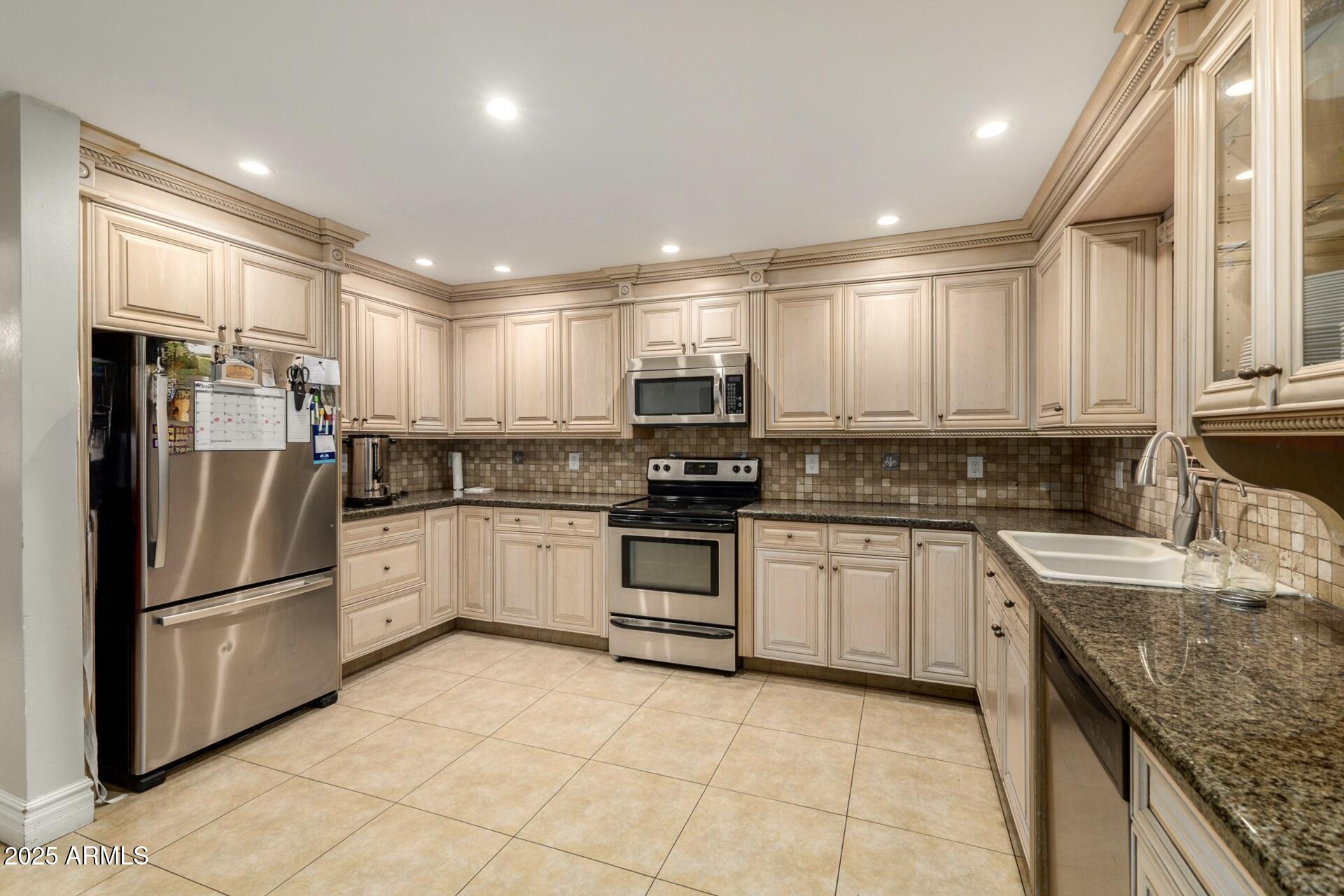6842 North 10th Place Phoenix, AZ 85014 - Photo 14 of 60 a kitchen with granite countertop a refrigerator stove top oven and sink