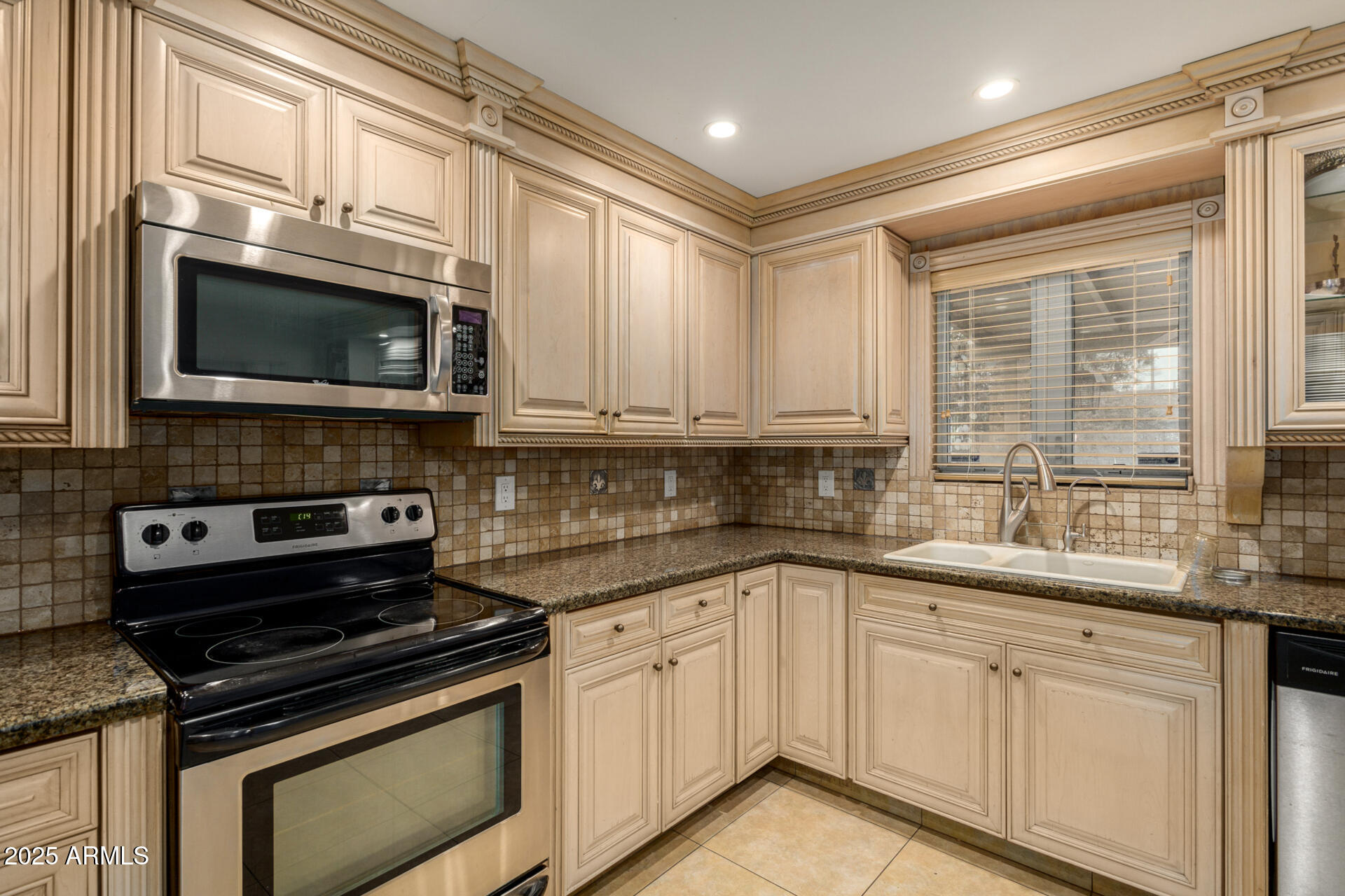6842 North 10th Place Phoenix, AZ 85014 - Photo 16 of 60 a kitchen with stainless steel appliances granite countertop white cabinets and a stove top oven