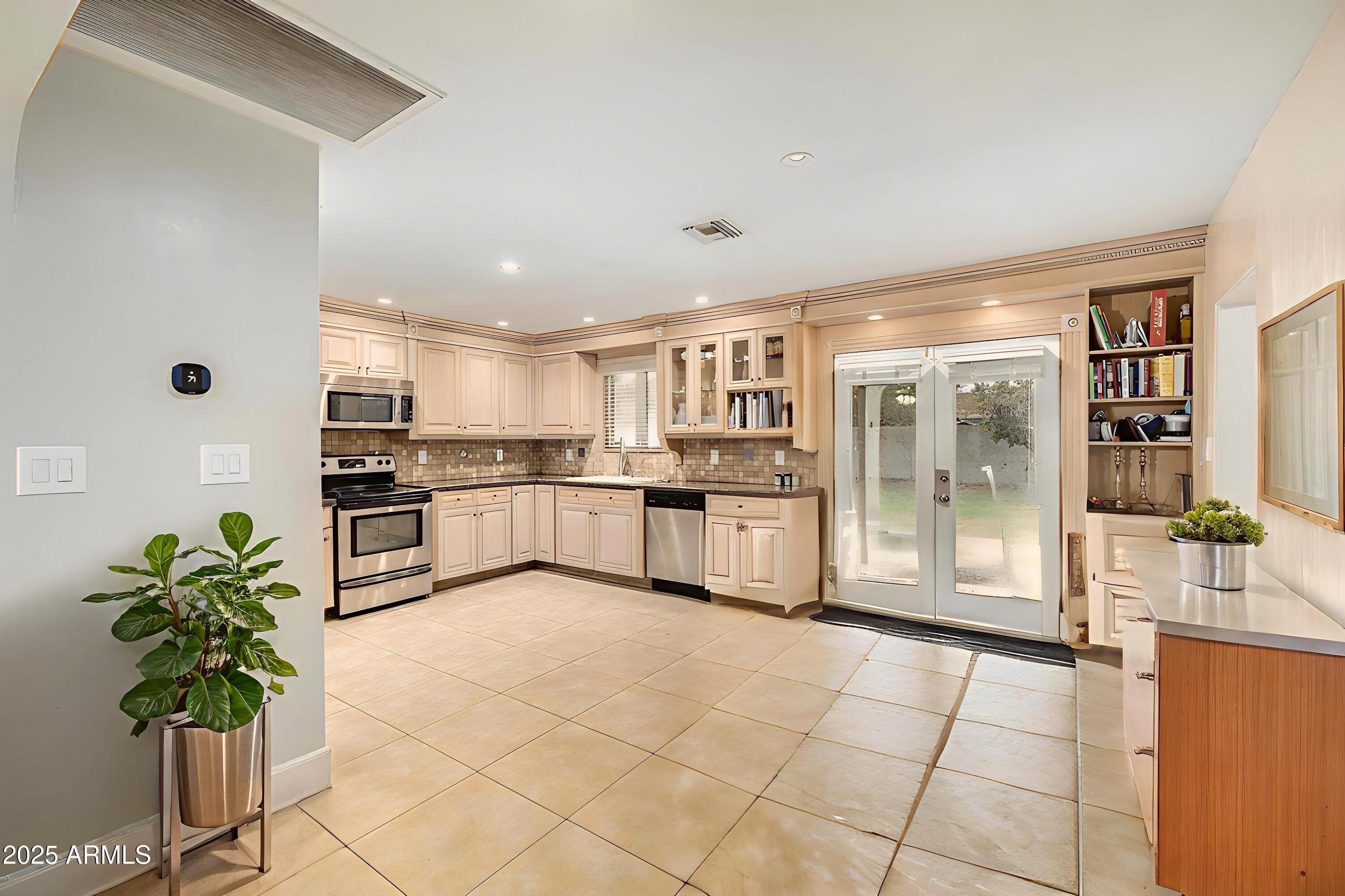 6842 North 10th Place Phoenix, AZ 85014 - Photo 19 of 60 a large white kitchen with cabinets and a potted plant