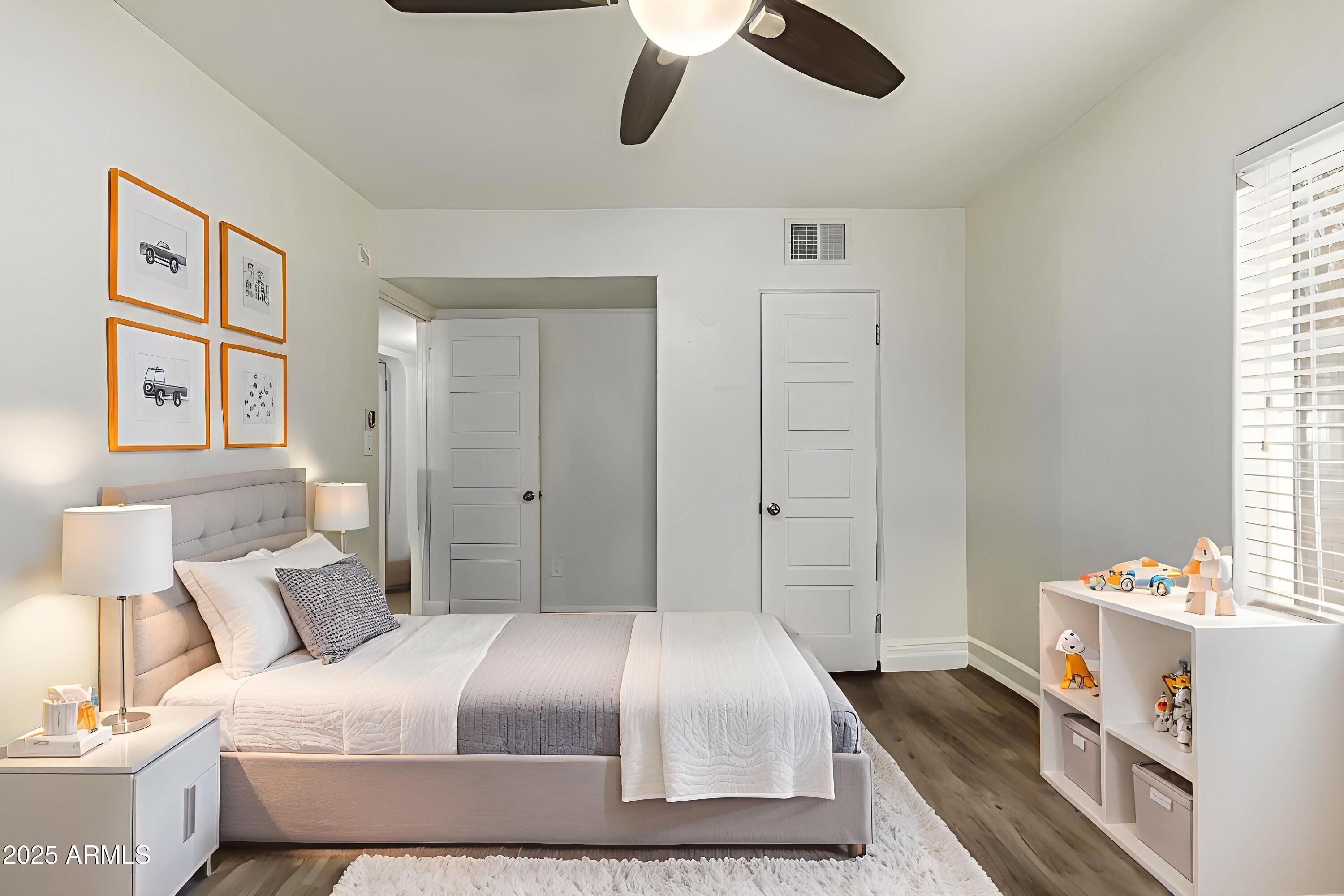6842 North 10th Place Phoenix, AZ 85014 - Photo 28 of 60 a bedroom with a large bed and a chandelier