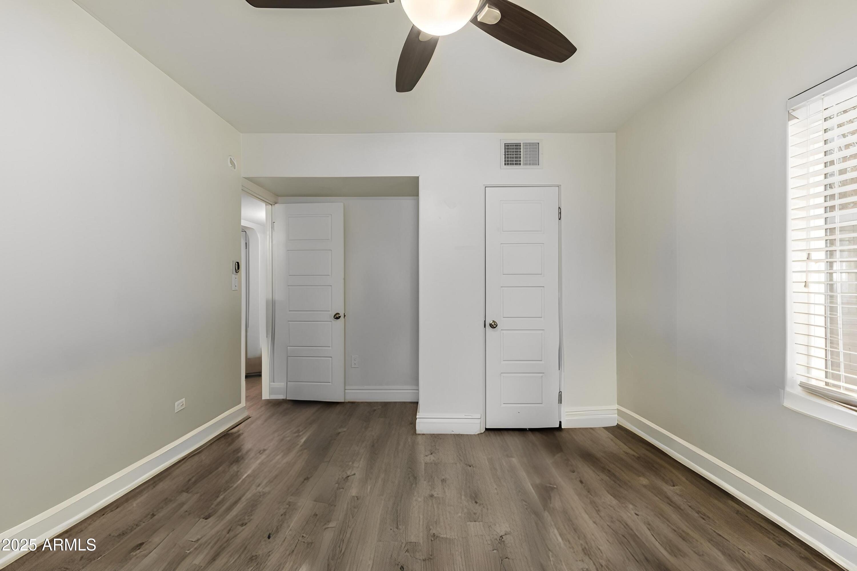 6842 North 10th Place Phoenix, AZ 85014 - Photo 30 of 60 an empty room with wooden floor cabinet and windows