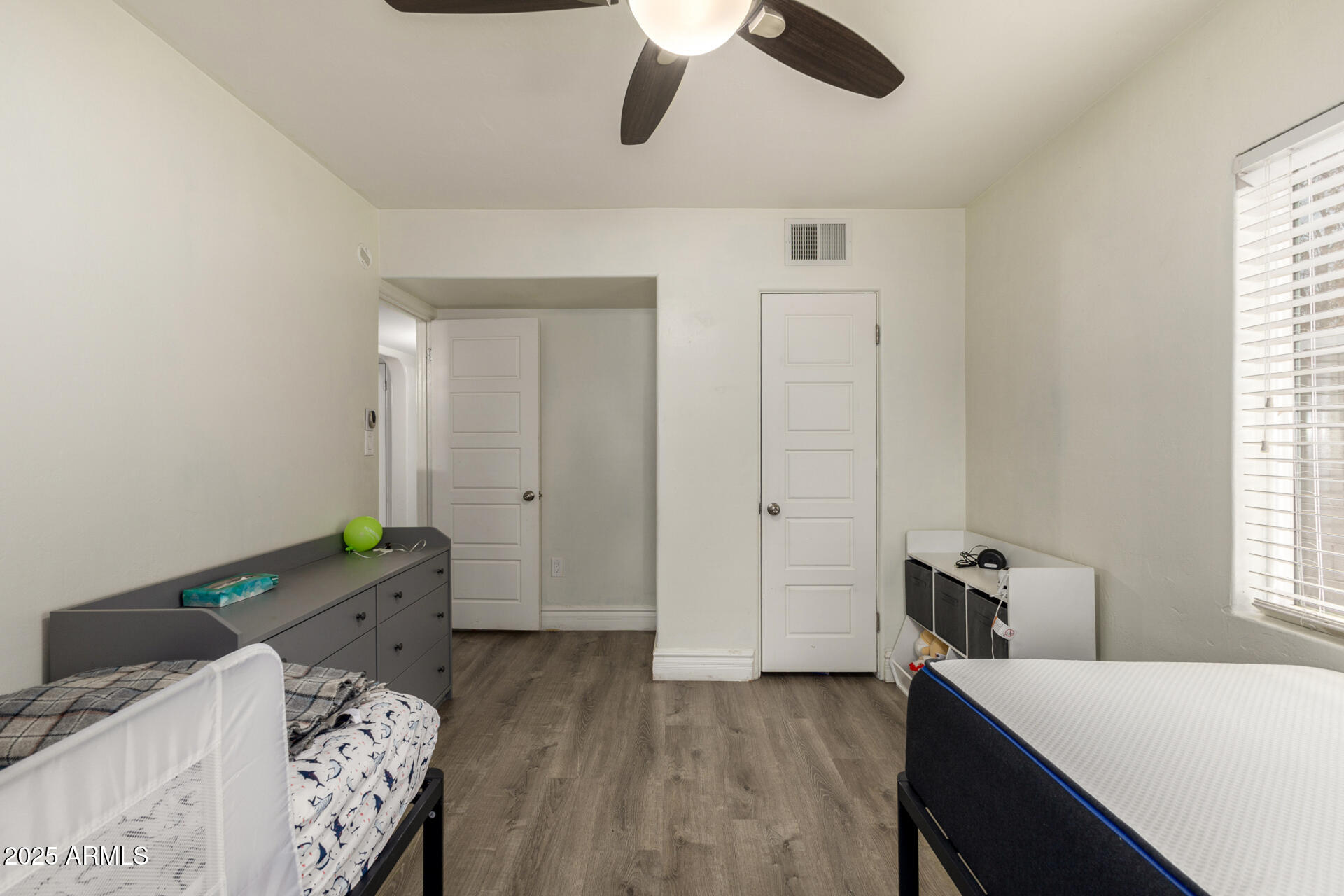 6842 North 10th Place Phoenix, AZ 85014 - Photo 32 of 60 a bedroom with a bed and wooden floor