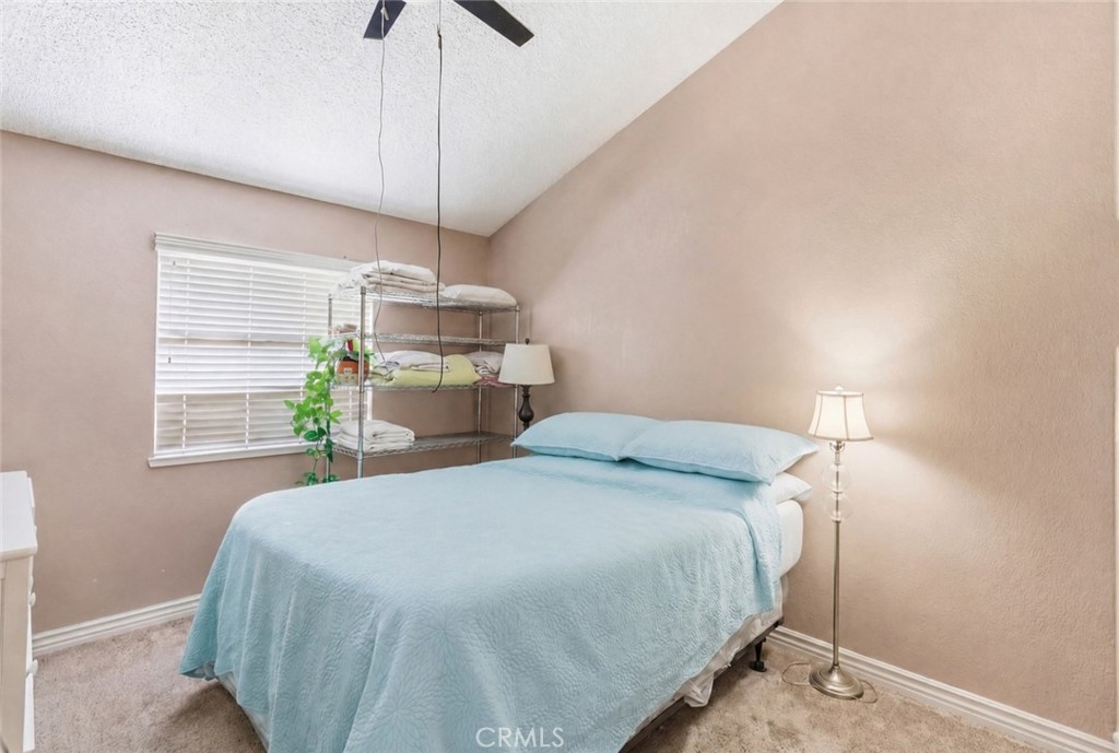 7800 Westfield Road, Unit 28 Bakersfield, CA 93309 - Photo 8 of 16 a bedroom with a bed and a chandelier