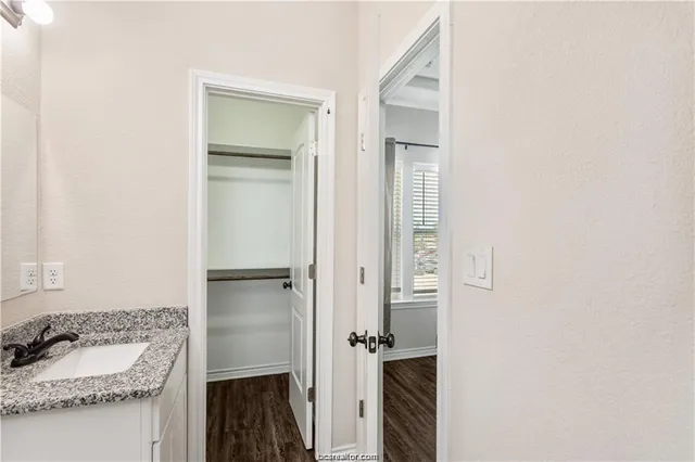 a bathroom with a granite countertop sink and a mirror