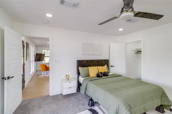 a bedroom with a large bed and ceiling fan